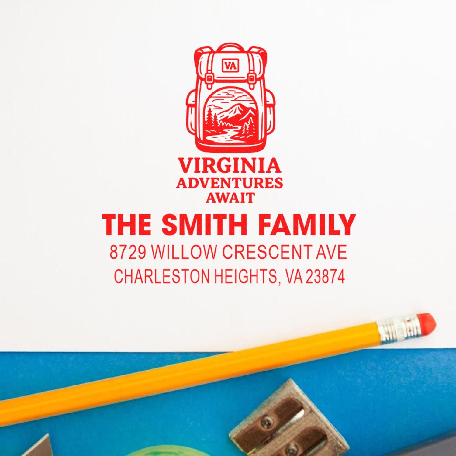 Red personalized Virginia adventure address stamp with backpack graphic, family name, and home address on white paper beside a pencil.