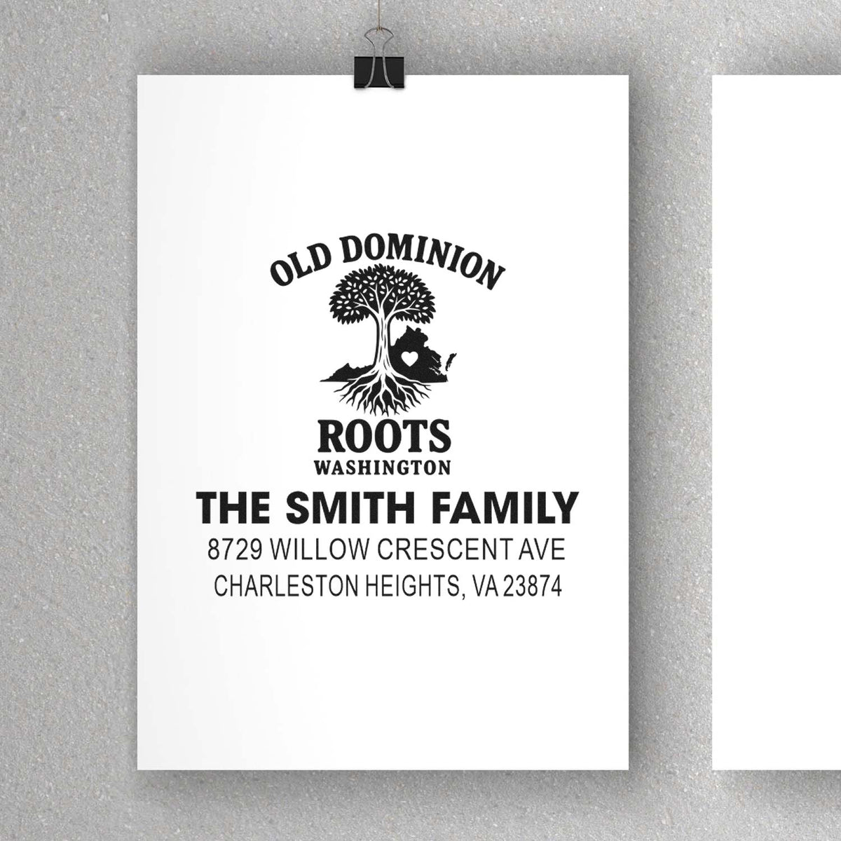 Custom address stamp design with tree logo and Old Dominion Roots Washington, The Smith Family, on clipped white paper against a gray wall.