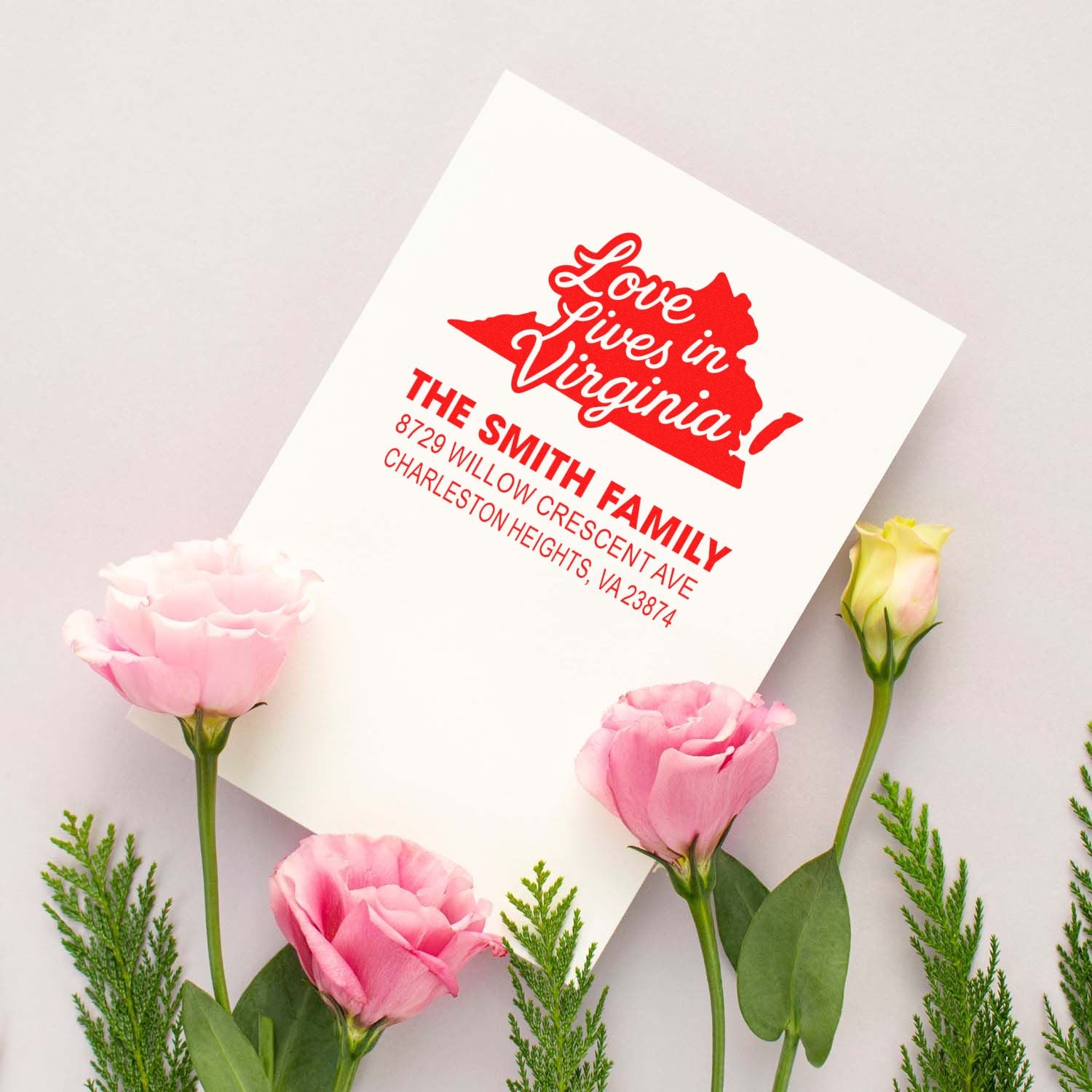 Personalized red address stamp reading Love Lives in Virginia with Smith Family address, styled on white card with pink flowers.