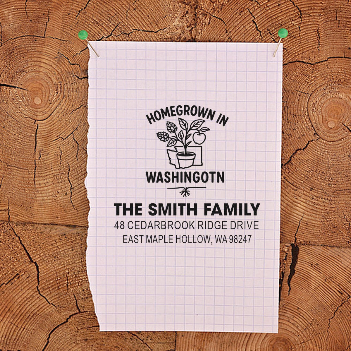 Custom address stamp design on pinned graph paper with Homegrown in Washington plant motif and Smith family address on rustic wood background.