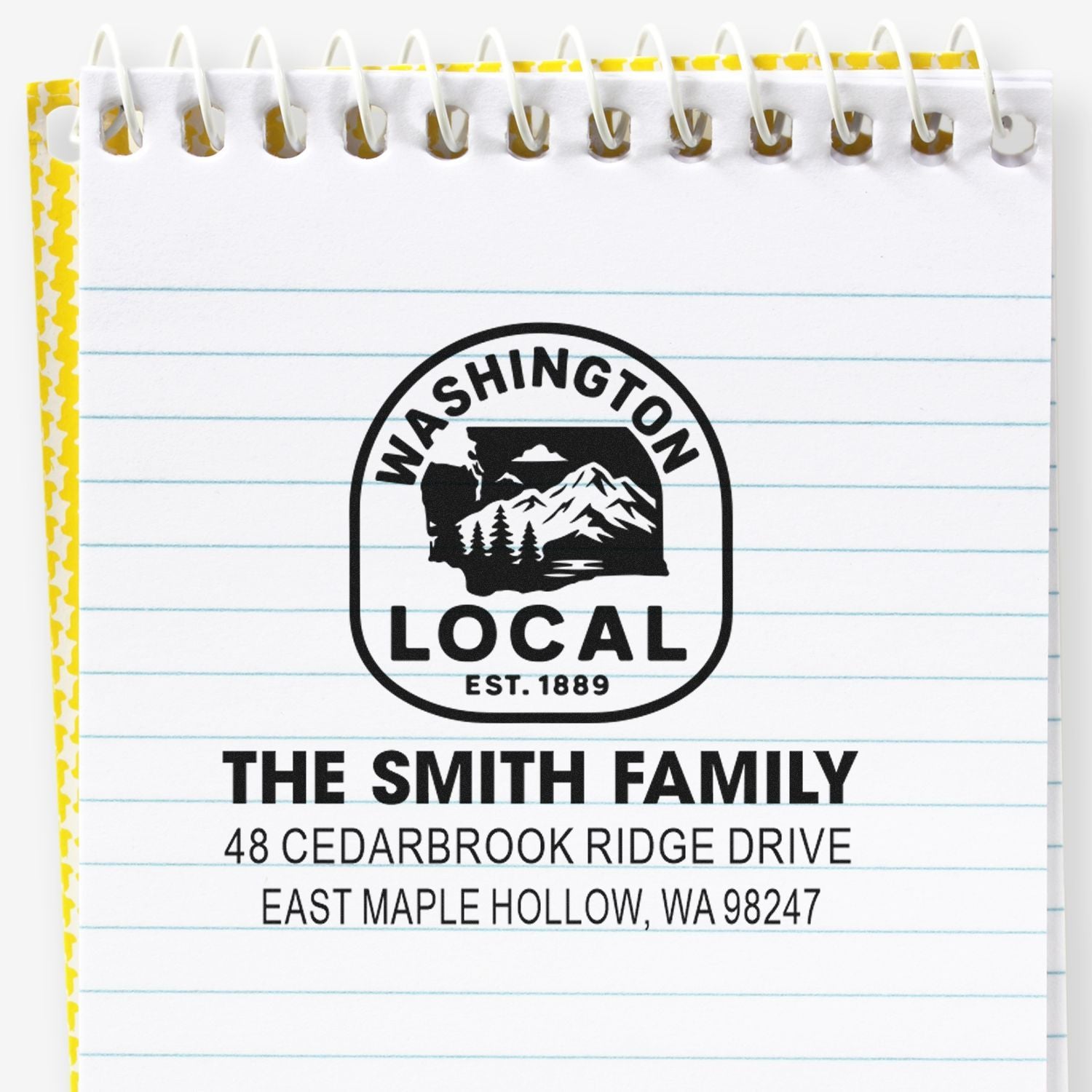 Custom Washington Local address stamp sample on lined spiral notebook, featuring The Smith Family address and mountain logo.