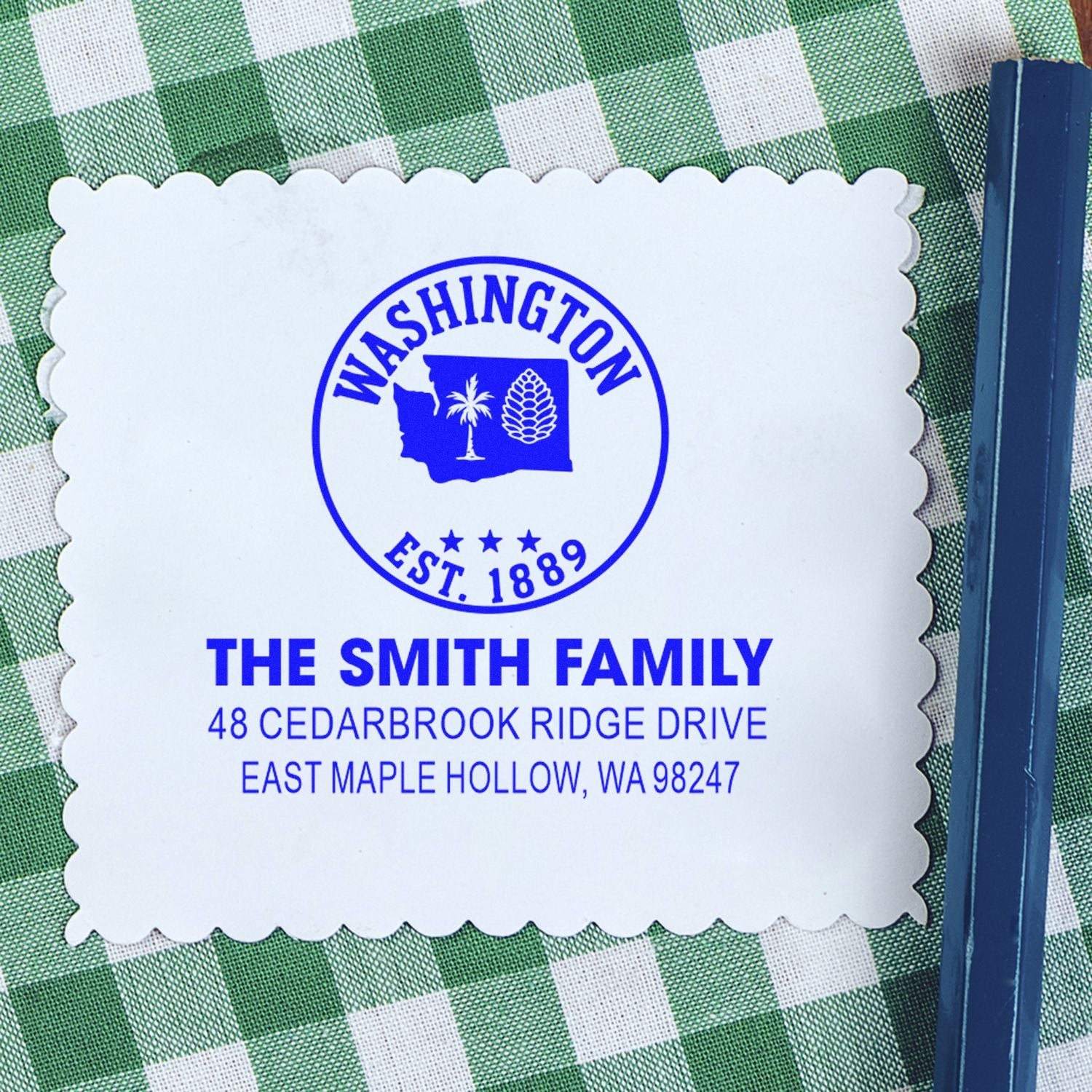 Personalized Washington address stamp with scalloped edge, blue ink design, and Smith family name on green gingham background.