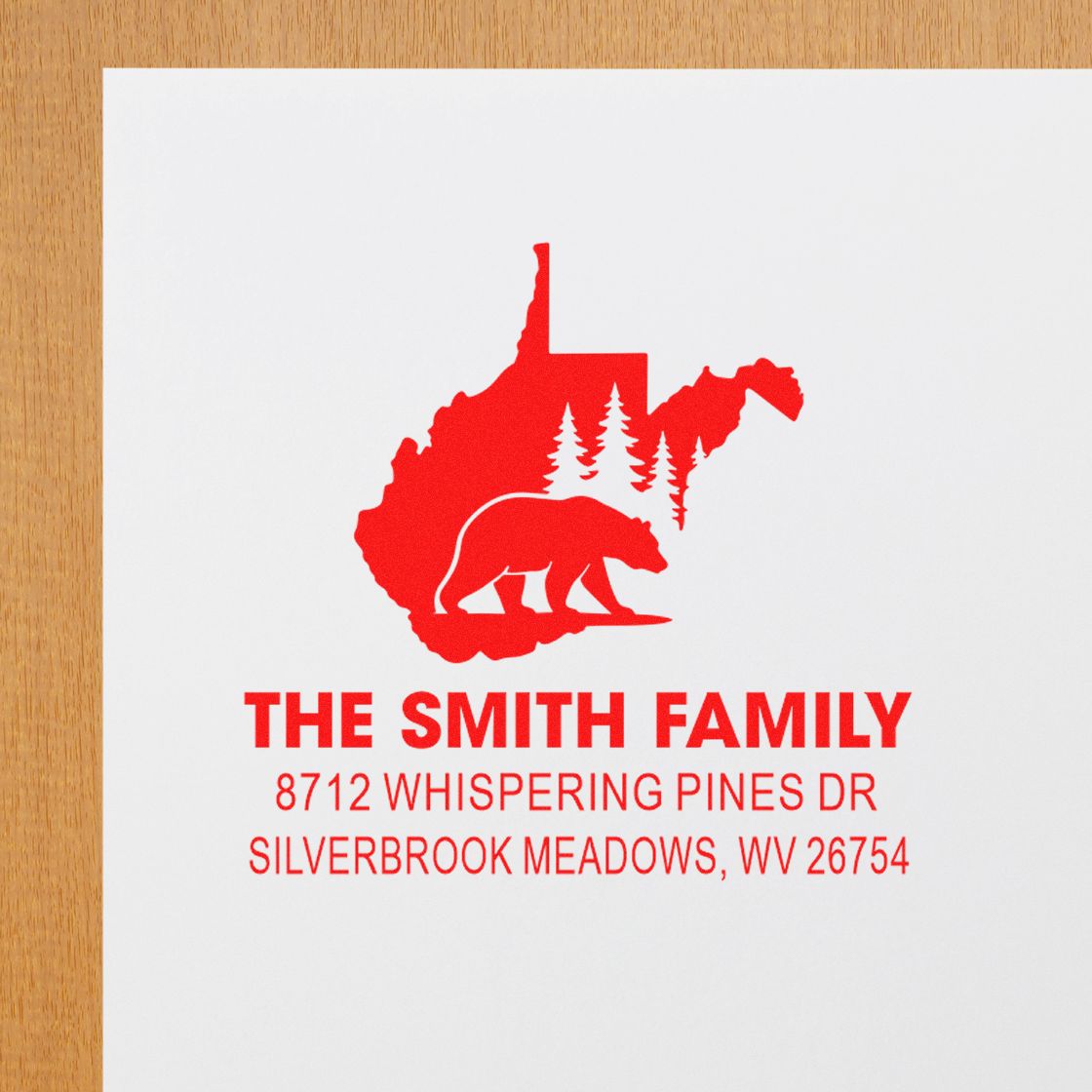 Personalized address stamp with red West Virginia bear and pine tree design on white paper, reading The Smith Family, 8712 Whispering Pines Dr, Silverbrook Meadows.