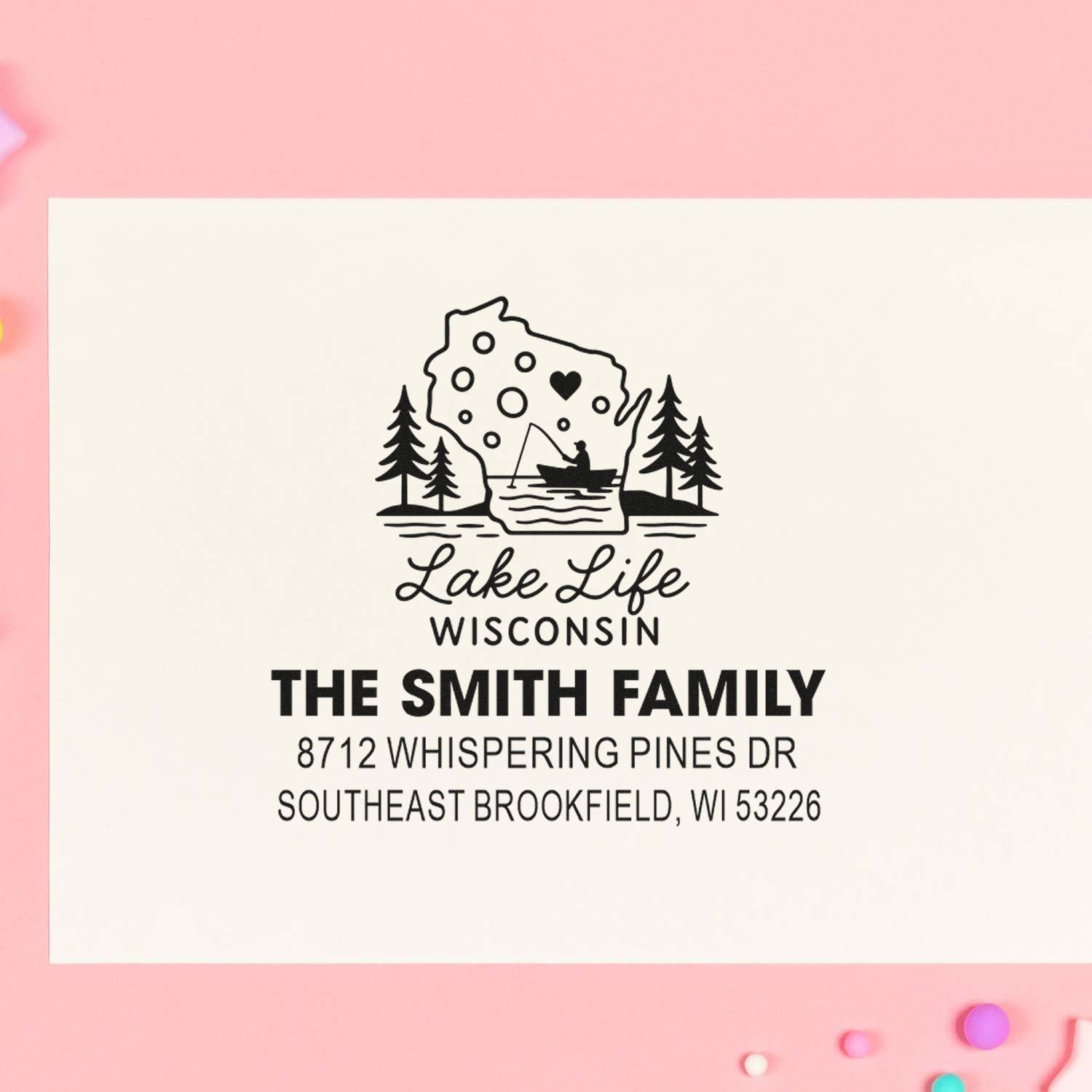 Personalized Wisconsin lake life address stamp with pine trees, fisherman in boat, and The Smith Family name on a pink background.