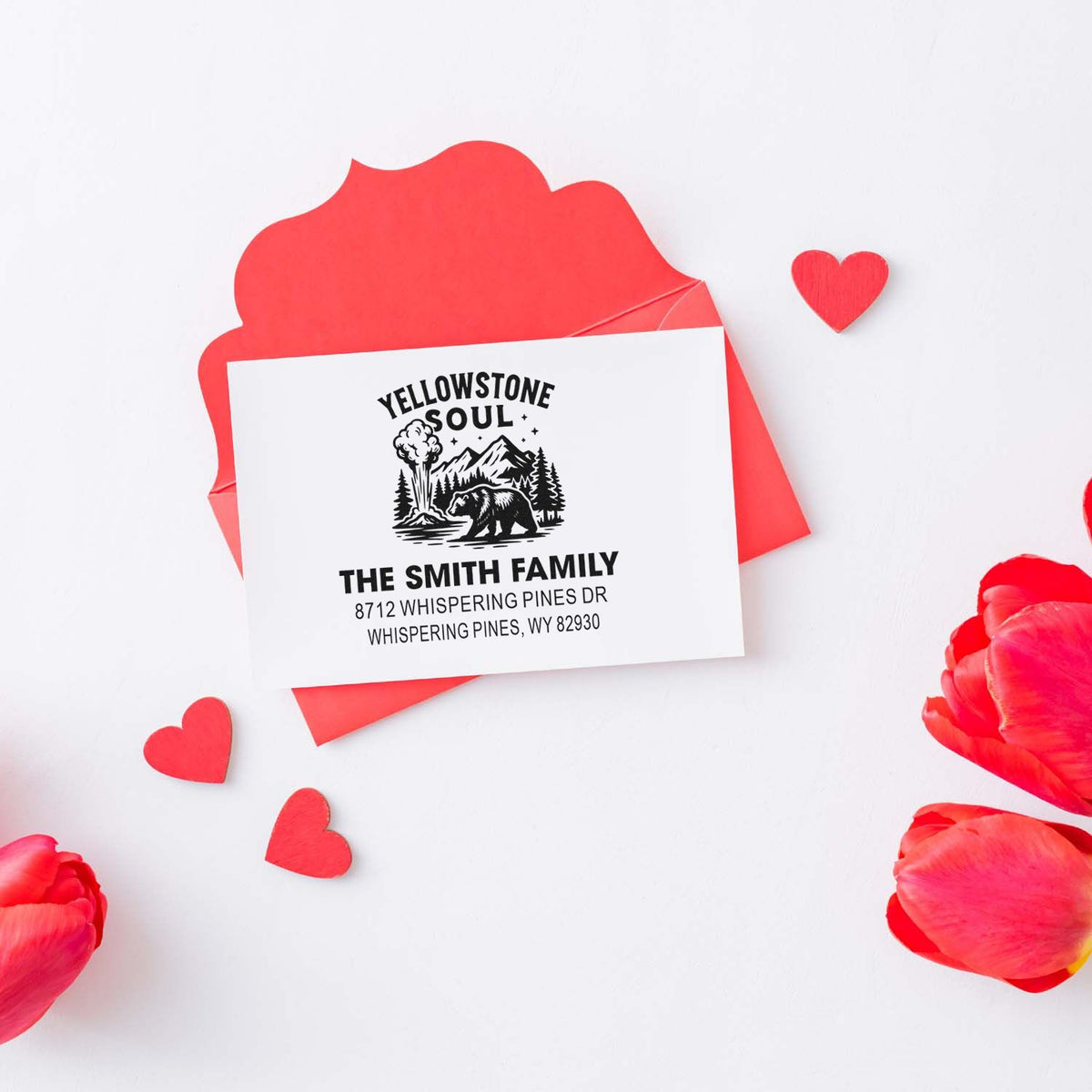 Custom Yellowstone Soul family address stamp on a red envelope, surrounded by heart cutouts and pink flower petals.