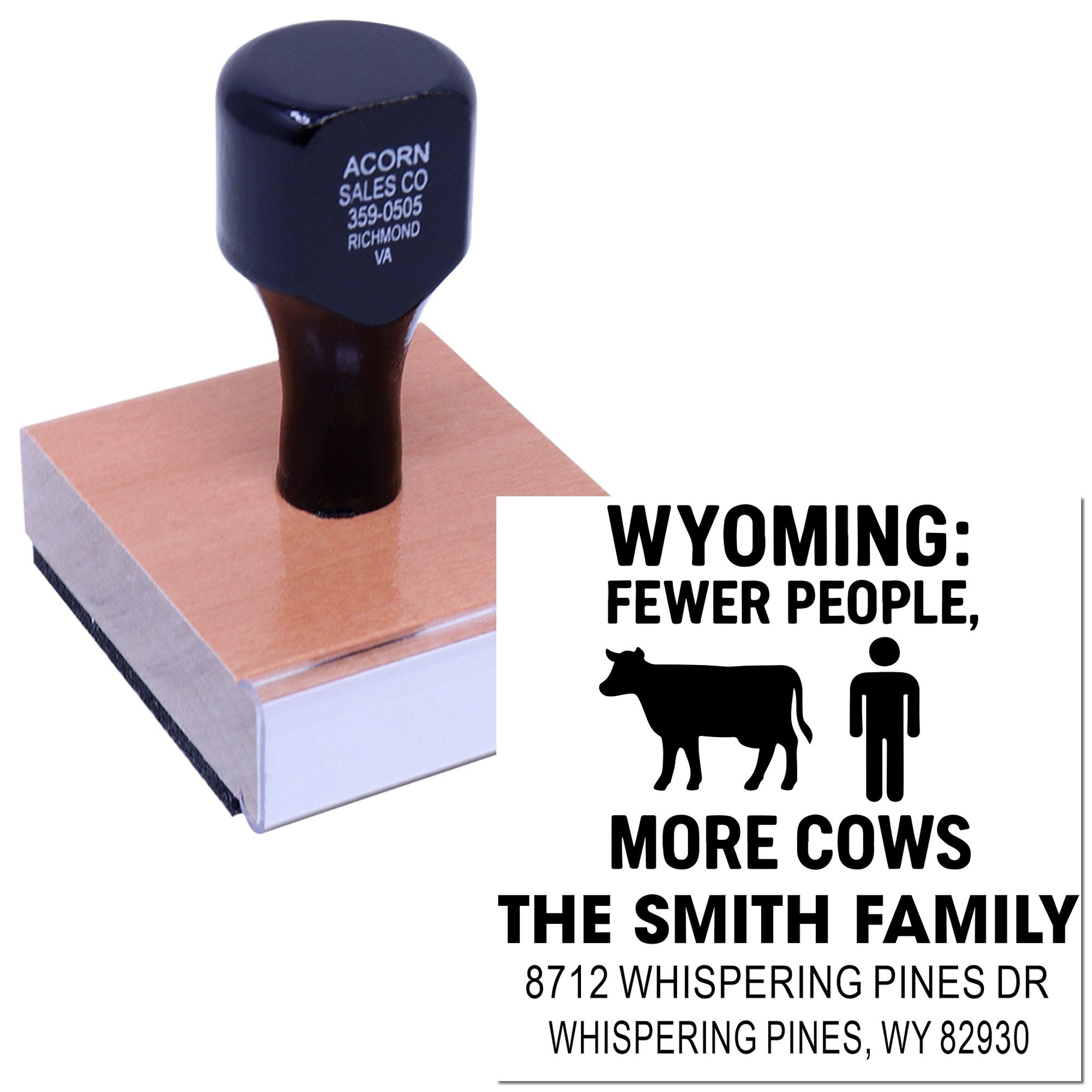 Custom rubber stamp on white background with Wyoming slogan, showing black hand stamp on wooden base beside imprint reading Fewer People, More Cows and address text.