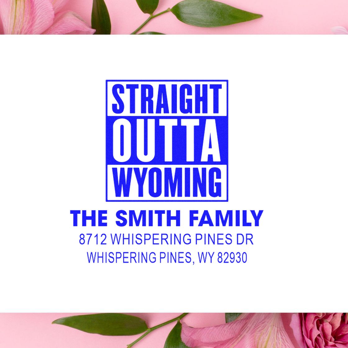 Blue custom address stamp reading Straight Outta Wyoming, The Smith Family, and Whispering Pines, WY 82930 on white with pink flowers.