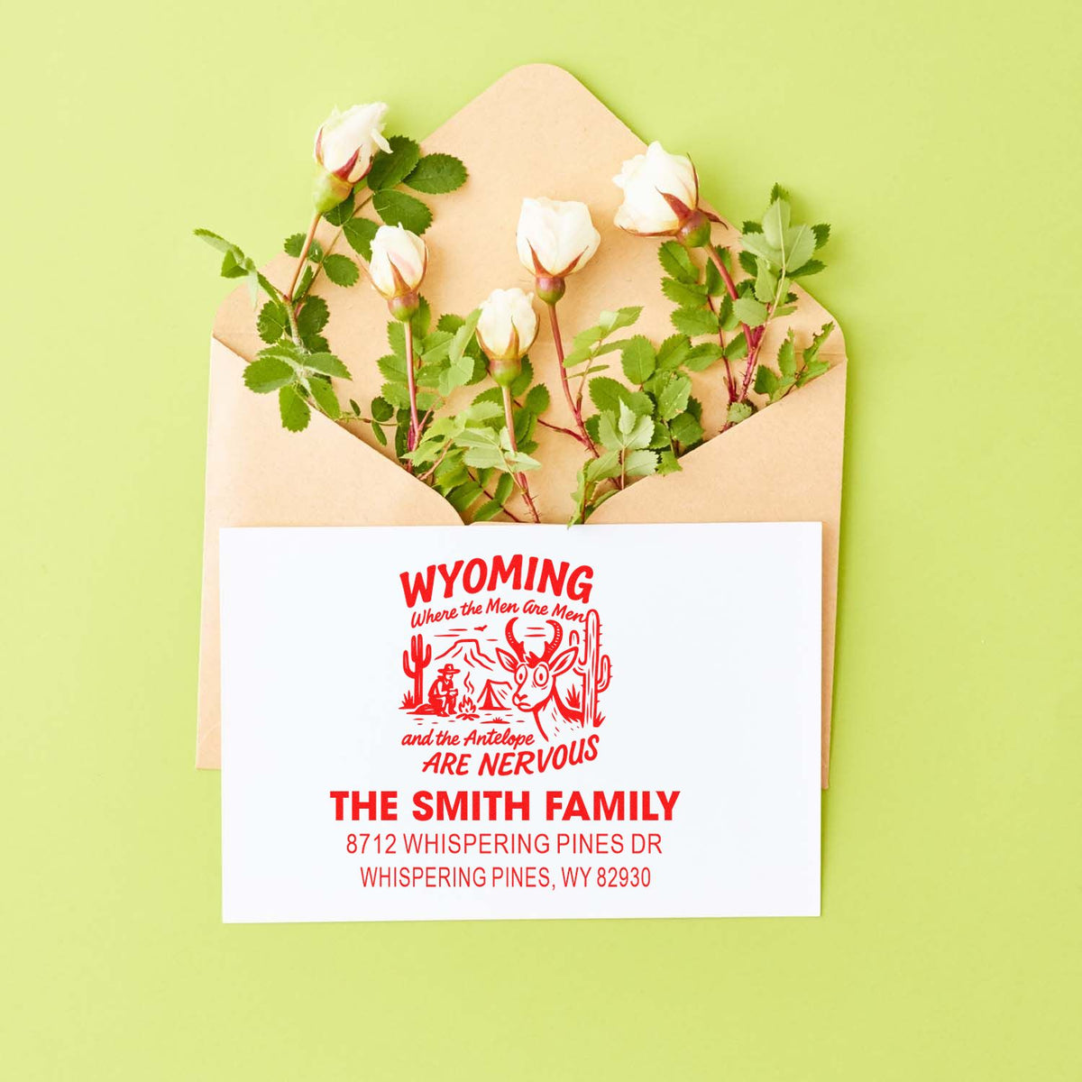 Custom Wyoming return address stamp on white mailer envelope with roses on green background, featuring The Smith Family and Whispering Pines address.