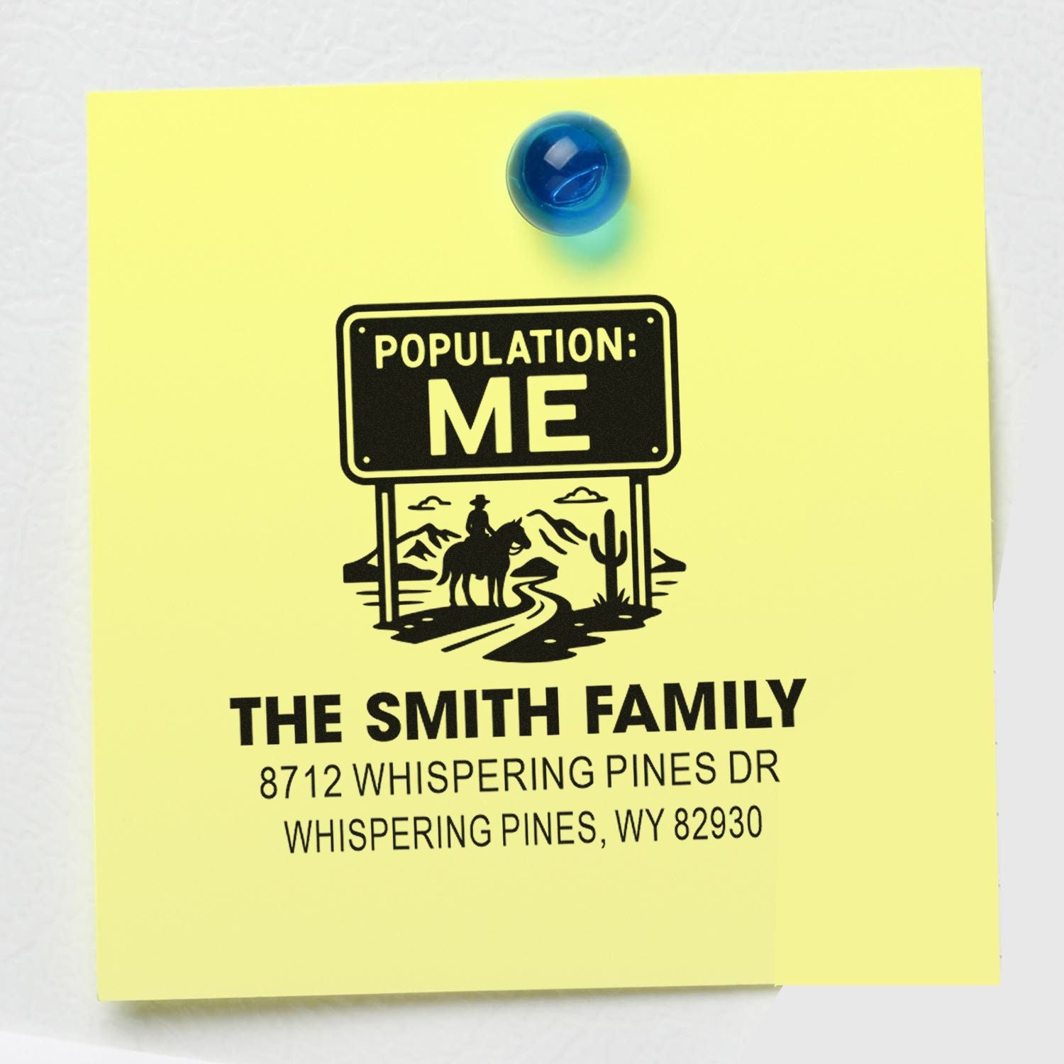 Custom family return address stamp on a yellow note card, reading Population: Me with desert rider graphic and blue pushpin.
