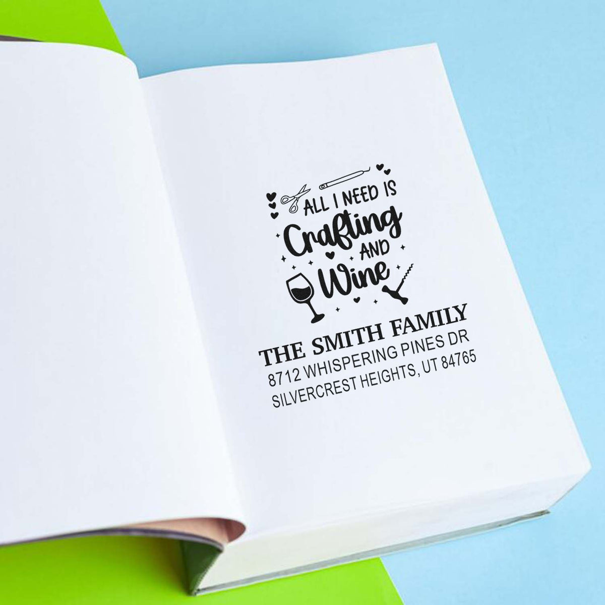 Personalized crafting and wine address stamp for The Smith Family on a white notebook page against a blue background.