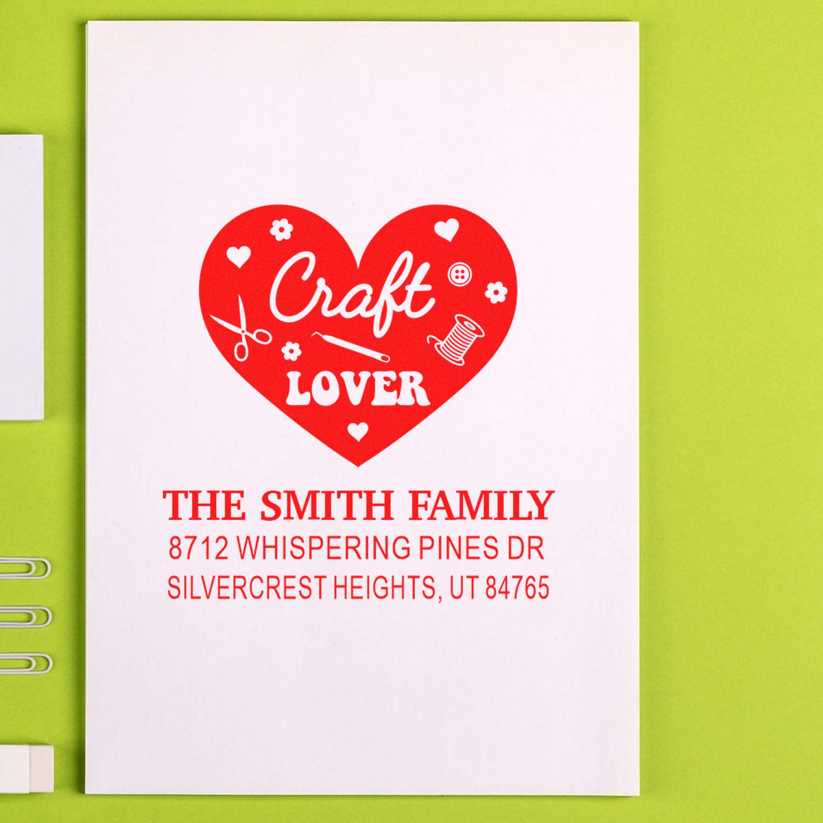 Custom heart-shaped craft lover address stamp for The Smith Family on white card, with scissors, spool and hearts on a lime green background.