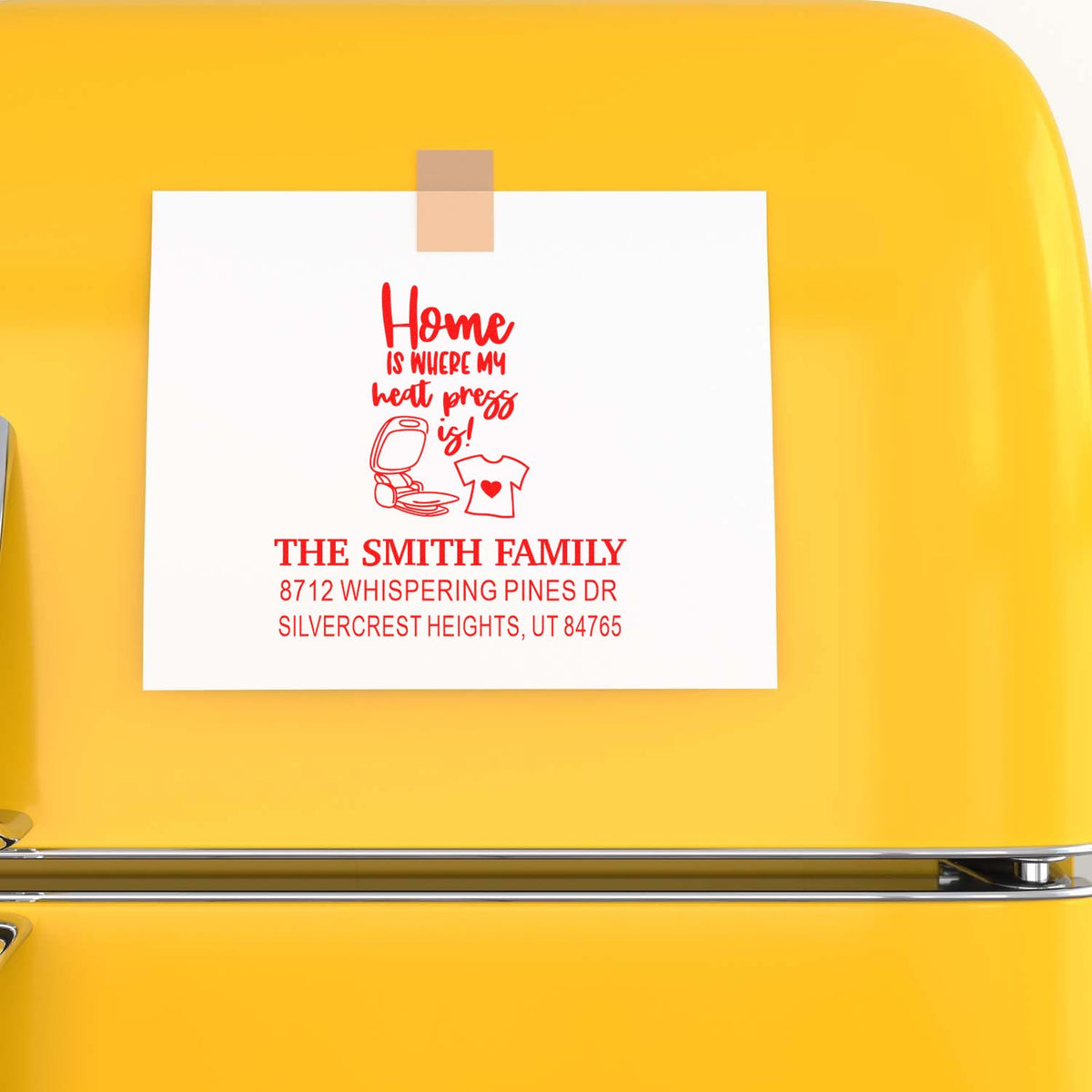 Personalized home address stamp design on white card taped to a bright yellow surface, featuring The Smith Family, heart and clothing press icons.
