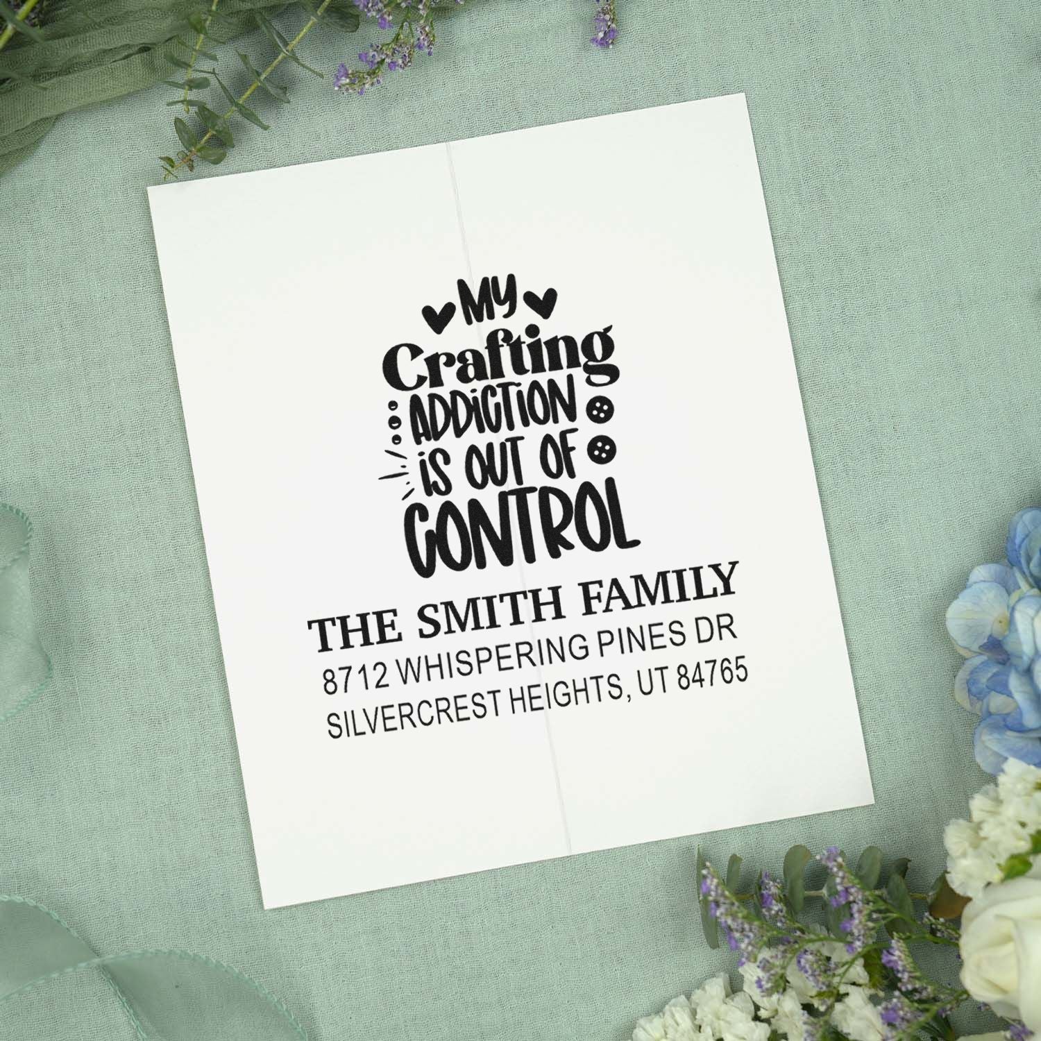 Custom crafting address stamp featuring My crafting addiction is out of control and The Smith Family address on a soft green floral backdrop.