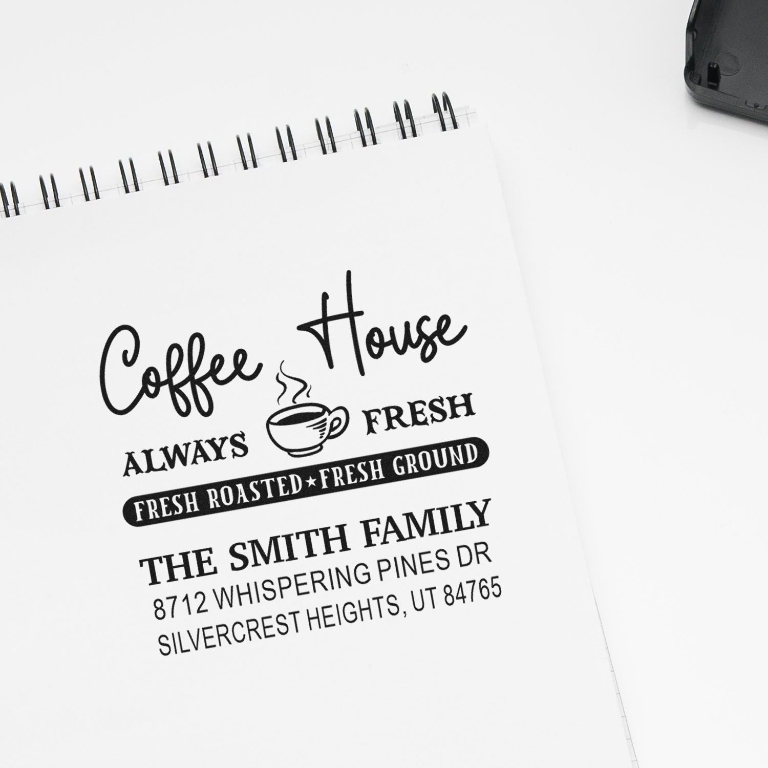 Custom coffee house address stamp on a spiral notebook, featuring Coffee House, fresh roasted fresh ground text, and family address details.