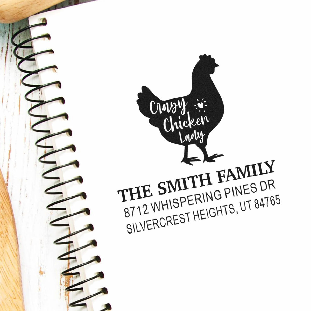 Custom return address stamp with Crazy Chicken Lady hen and The Smith Family address on a spiral notebook page.