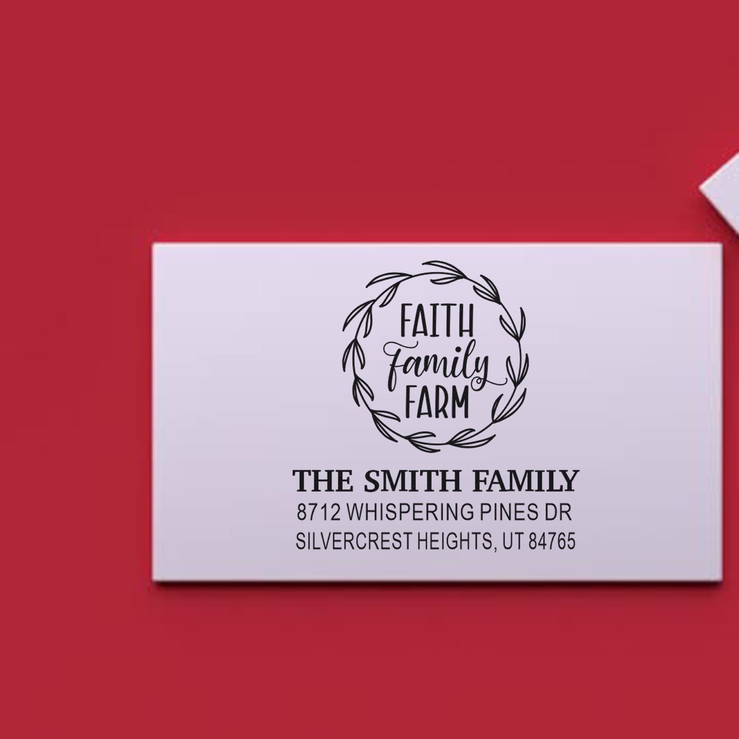 Custom return address stamp with Faith Family Farm wreath design, The Smith Family name, and address on a red background.