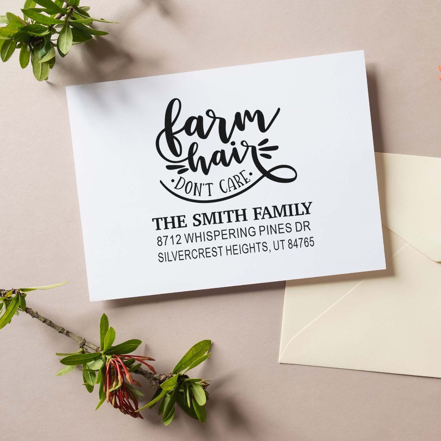 Custom farmhouse return address stamp reading farm hair dont care on white stationery, styled with envelope and greenery.