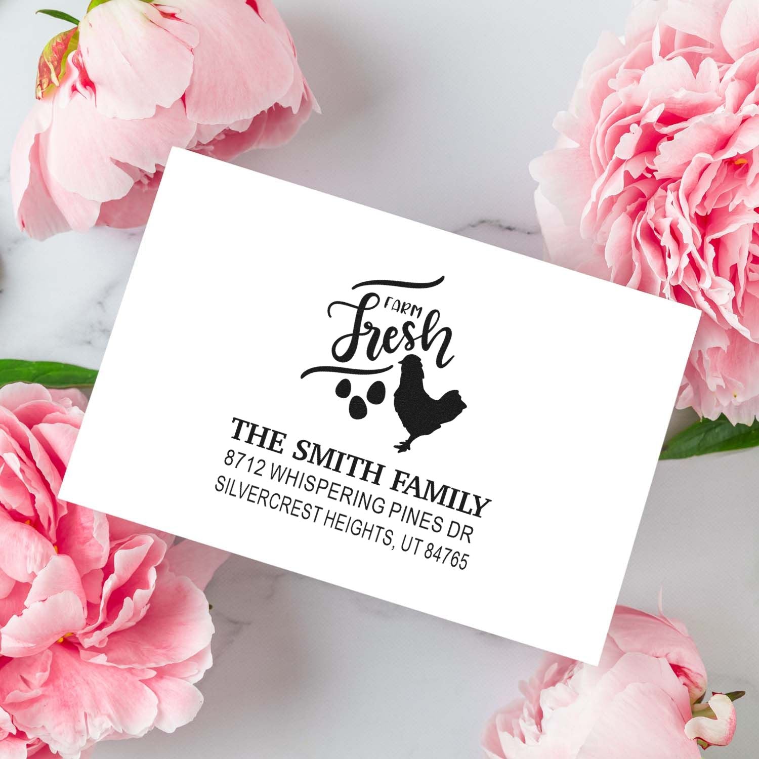 Custom address stamp with Farm Fresh chicken design and The Smith Family return address, styled on a marble surface with pink peonies.