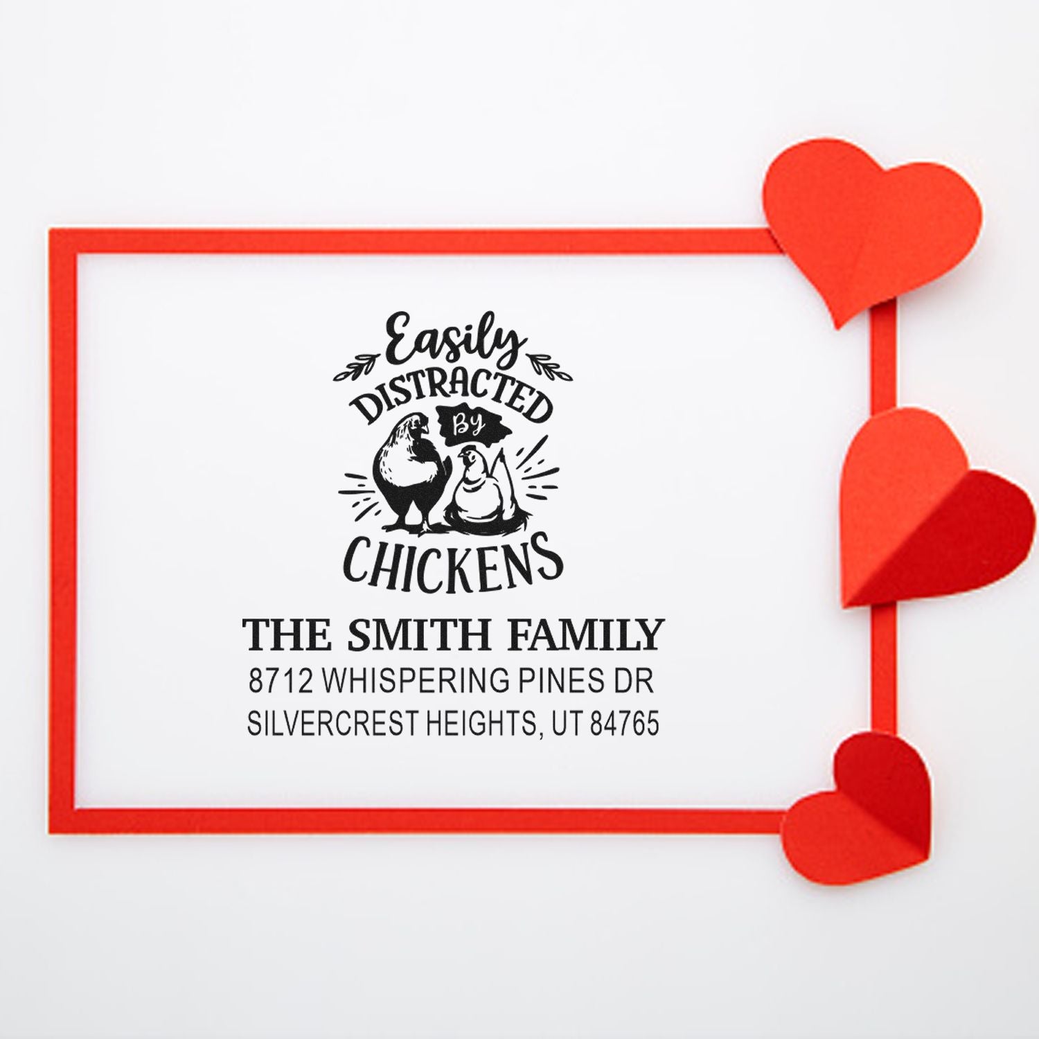 Personalized rubber stamp with Easily Distracted by Chickens design, red heart accents, and Smith family address on a white background.