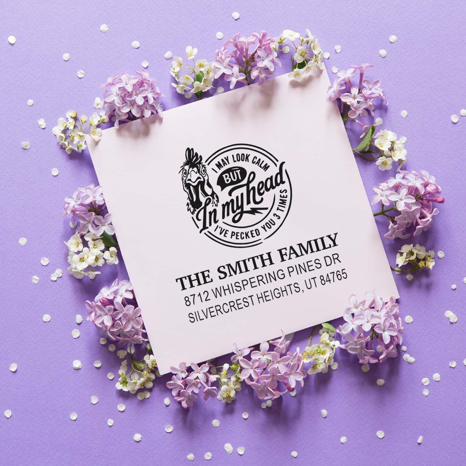 Custom self-inking address stamp with funny chicken design reading I may look calm but in my head Ive pecked you 3 times, on a floral purple backdrop.