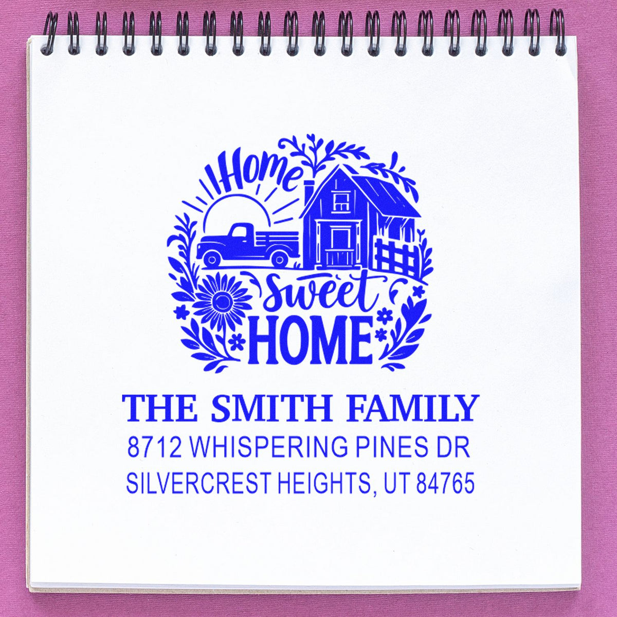 Blue custom return address stamp with Home Sweet Home farmhouse design, pickup truck, house, and Smith family address on a spiral notepad.