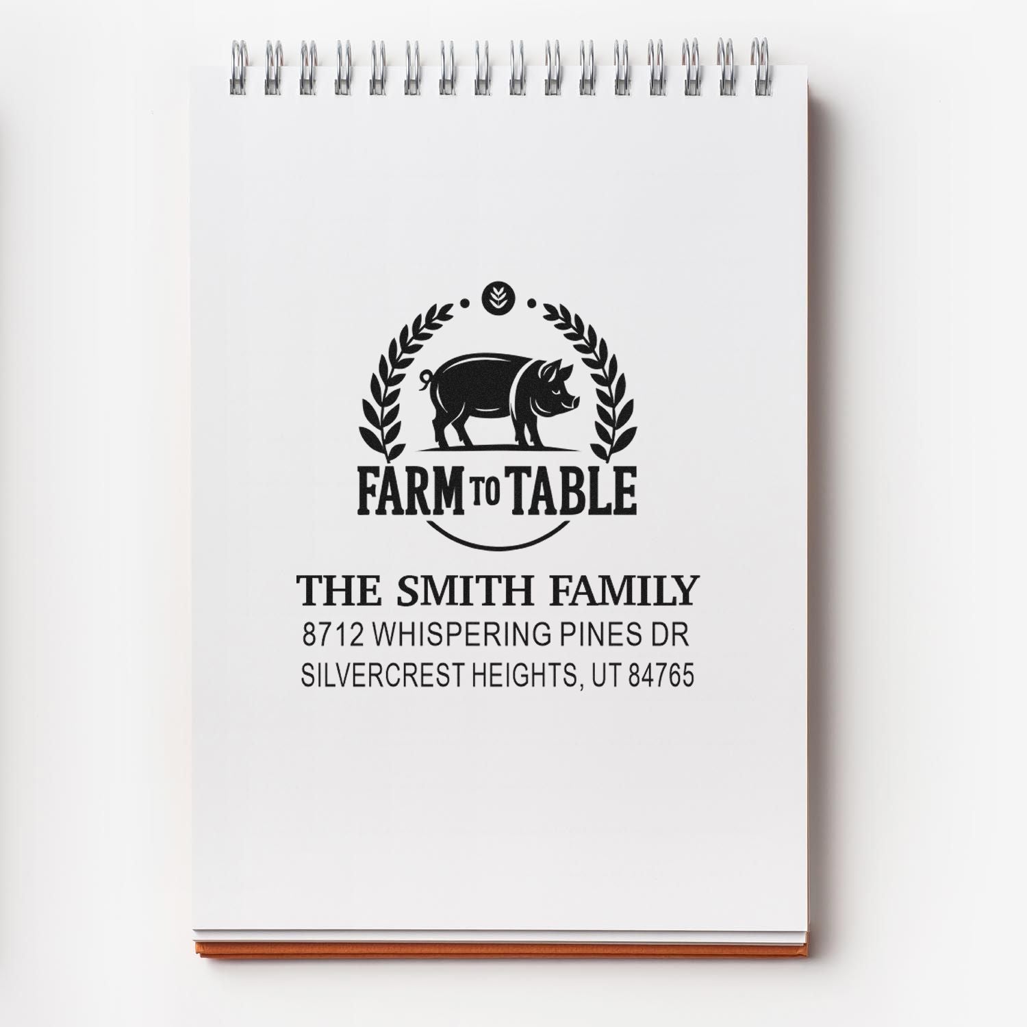 Custom farm-to-table return address stamp with pig and laurel logo, personalized for The Smith Family on a white spiral notepad card.