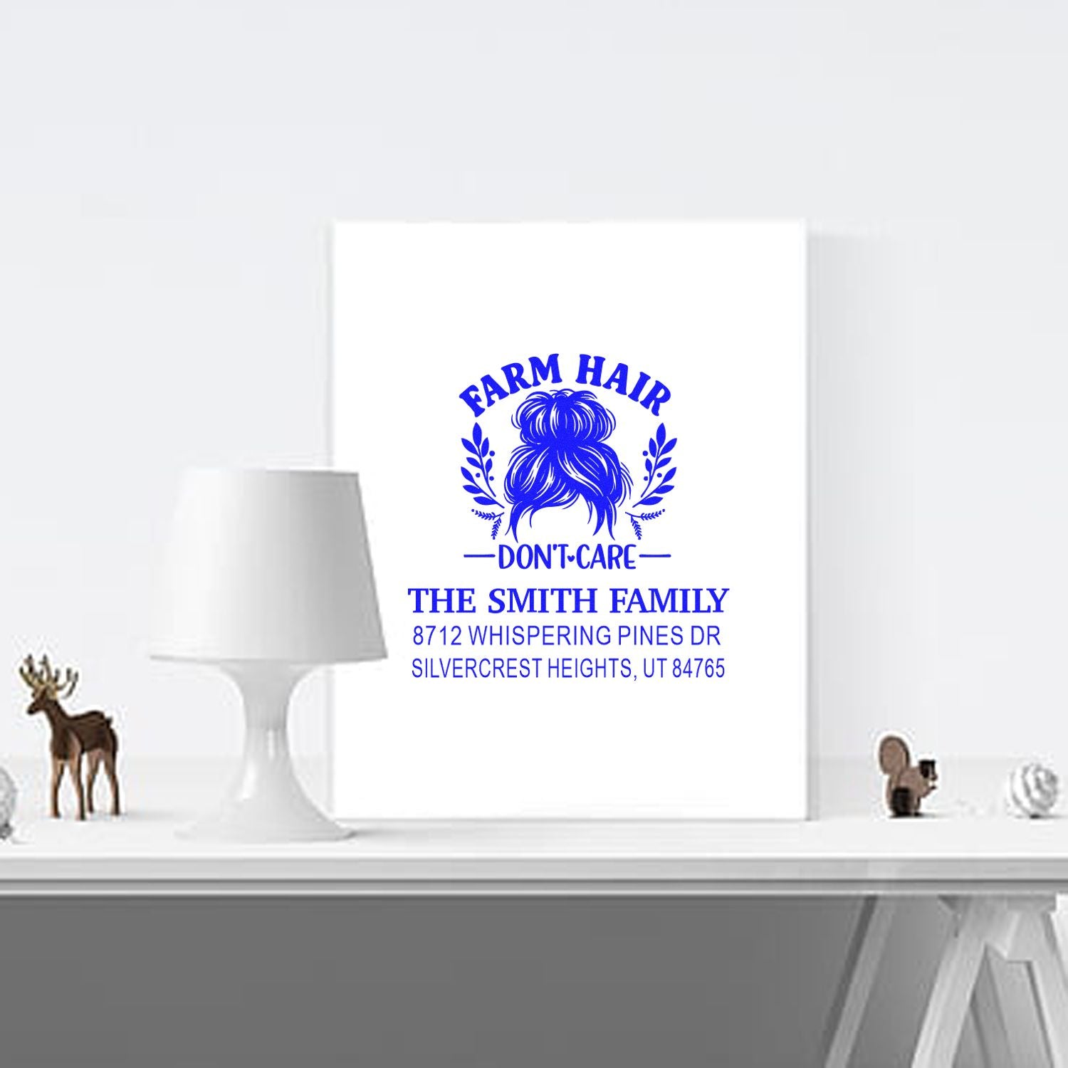 Custom Farm Hair Dont Care address stamp on white canvas in a bright room, styled with lamp and rustic deer decor on a shelf.