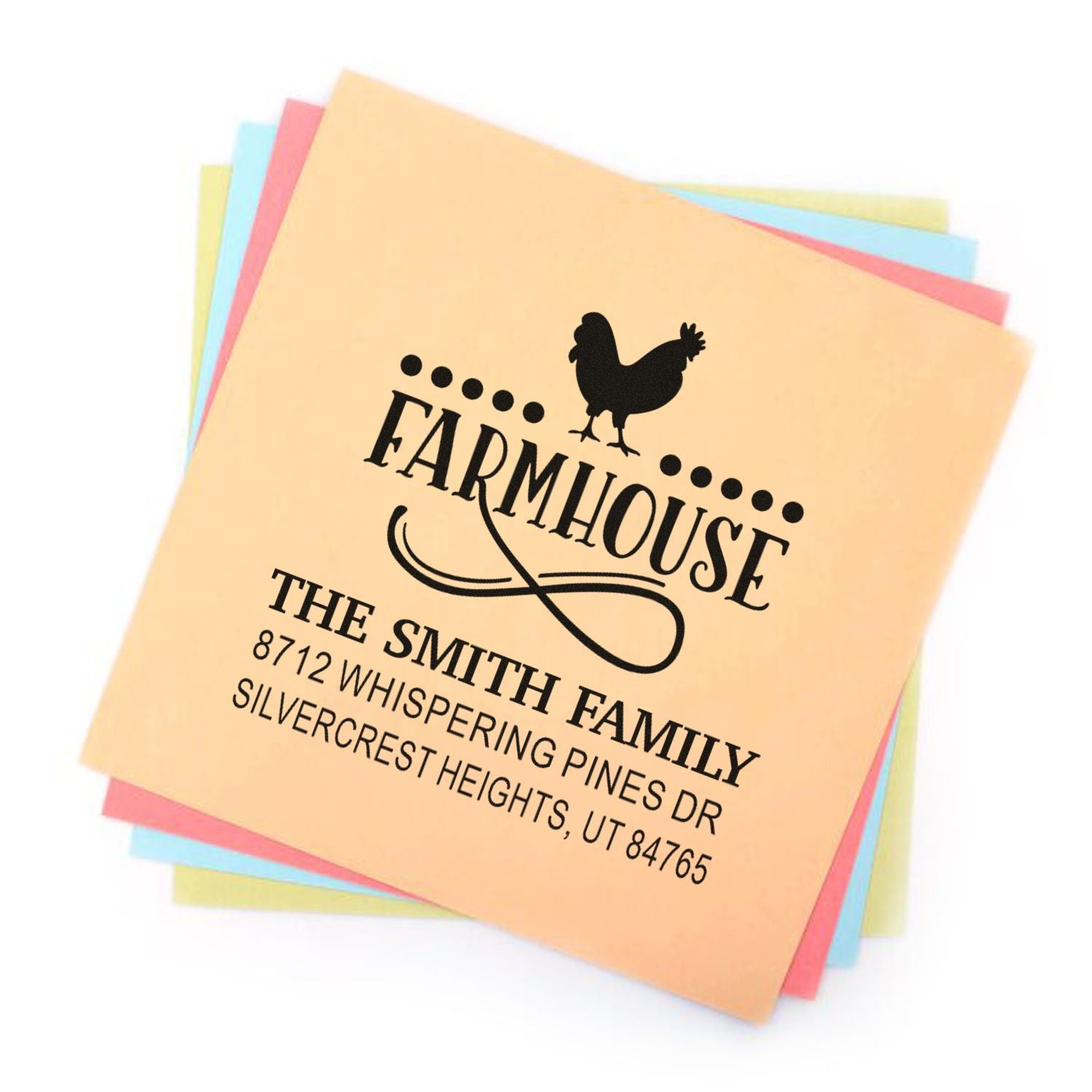 Custom farmhouse return address stamp with rooster and Smith family address on stacked pastel paper sheets.