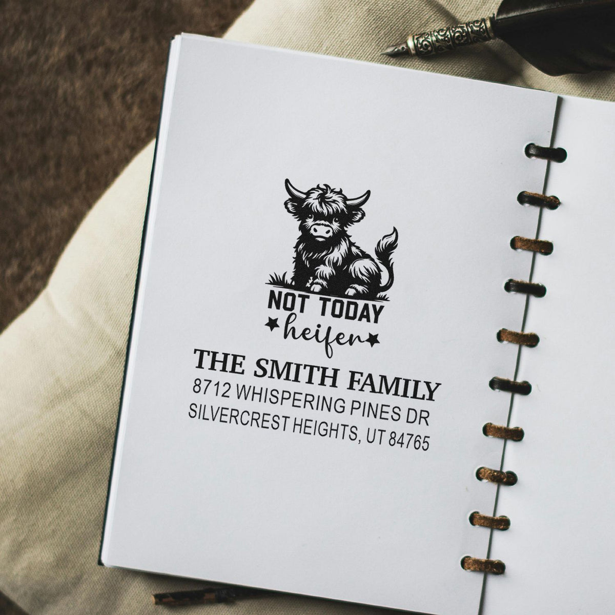 Custom rubber stamp on notebook page featuring a cow and Not Today heifer with The Smith Family address, beside a fountain pen.