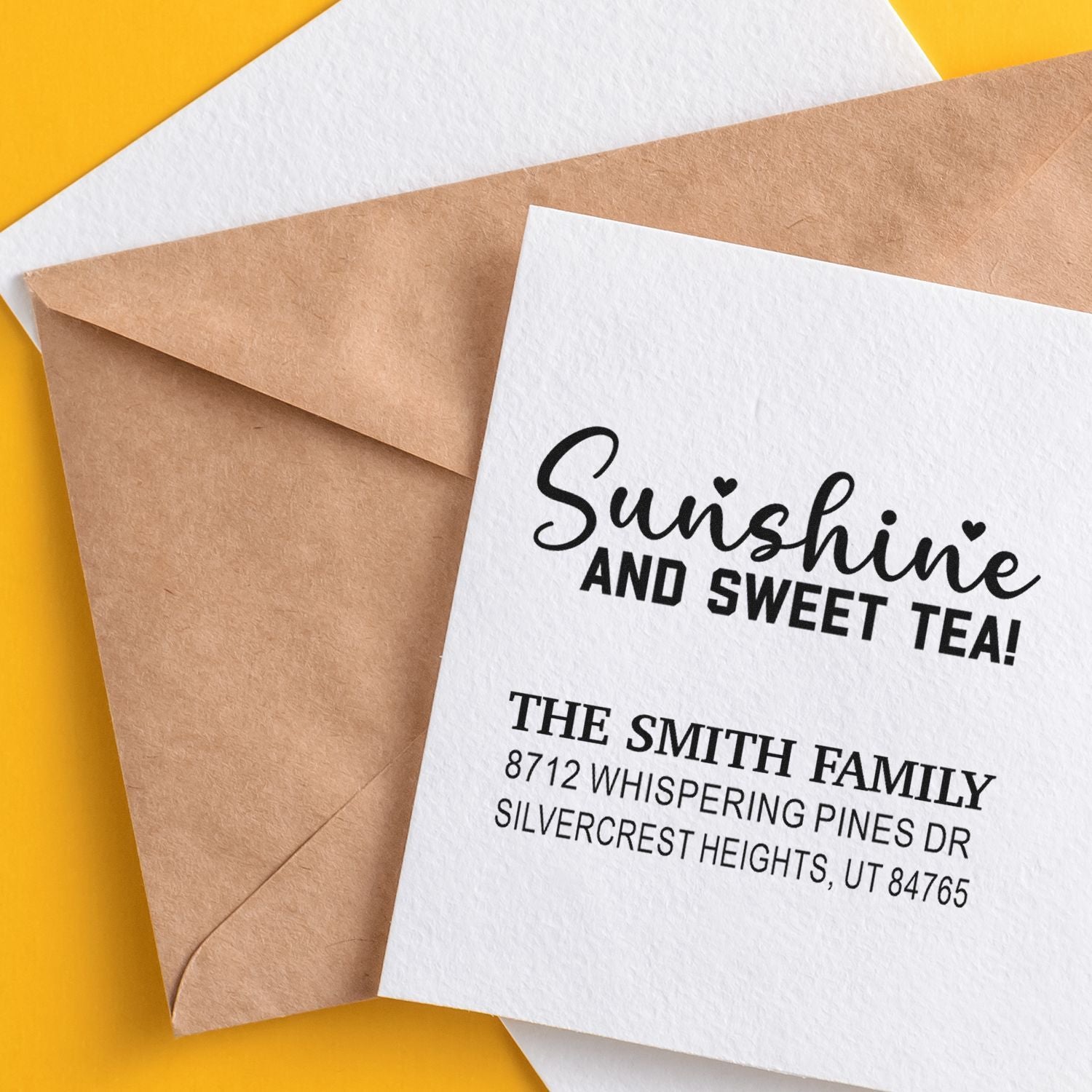 Custom address stamp reading Sunshine and Sweet Tea on white card with kraft envelope over a bright yellow background.