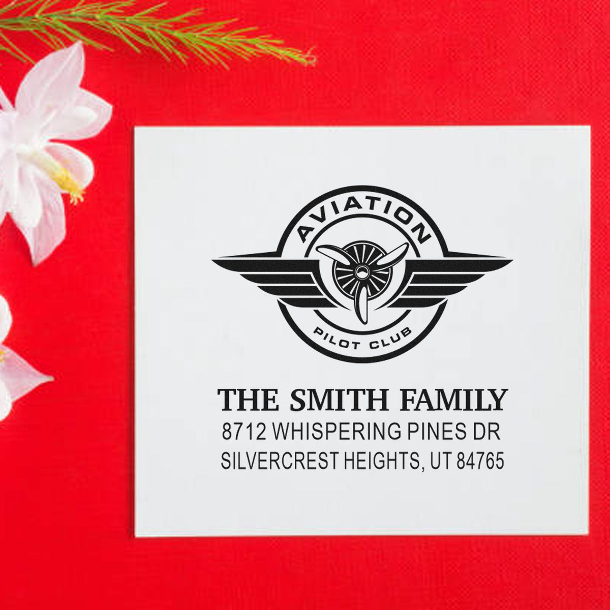 Custom aviation pilot club address stamp for The Smith Family, featuring a winged propeller logo on a white card with a red festive background.