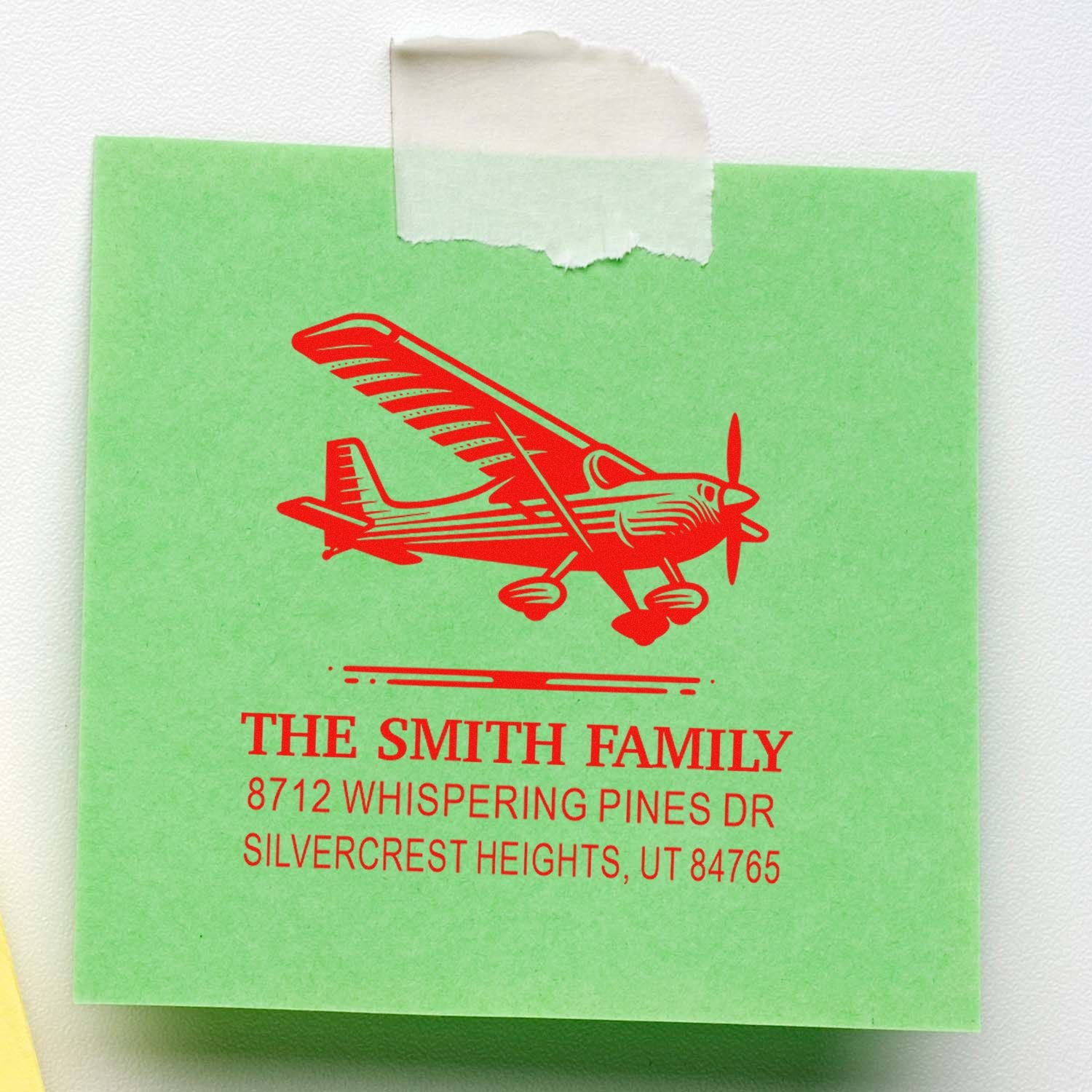 Green custom address stamp with red airplane graphic and The Smith Family return address on a white background.