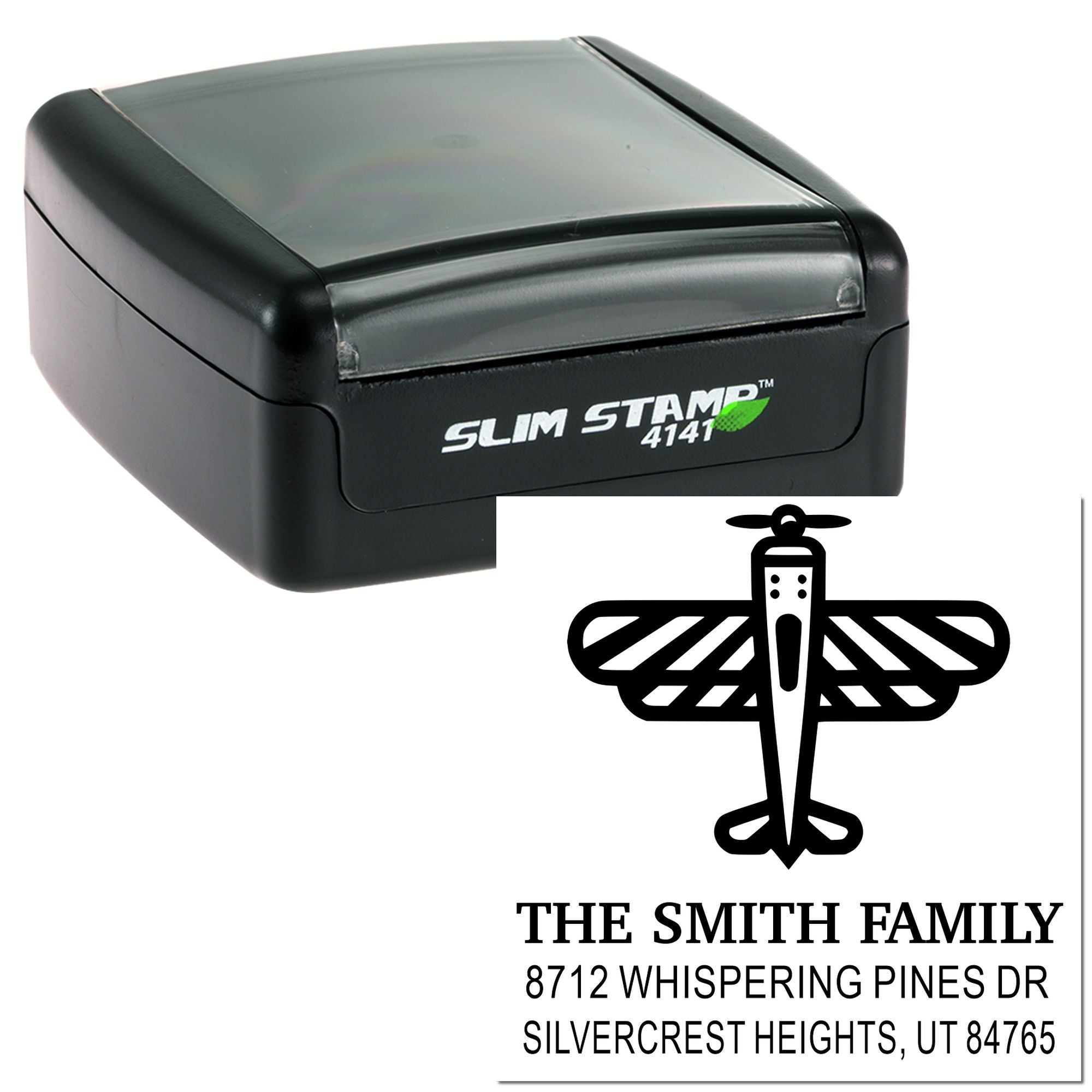 Slim self-inking address stamp with custom family name and return address, shown beside sample imprint on a white background.
