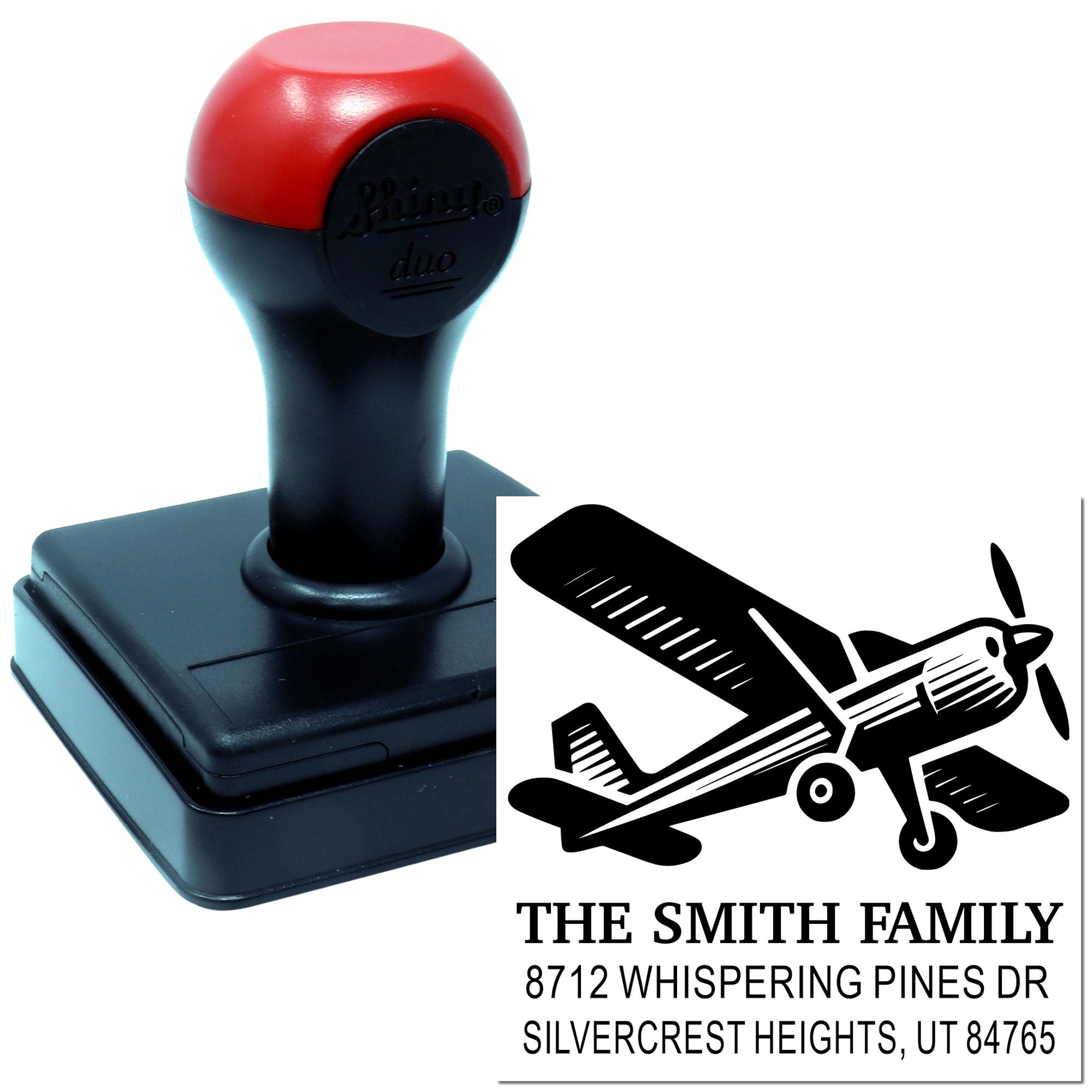 Custom self-inking stamp with airplane logo and The Smith Family address, shown beside a printed impression on a white background.