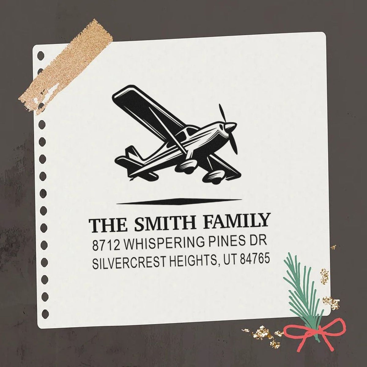 Custom address stamp with airplane graphic, notebook-style design, and The Smith Family, 8712 Whispering Pines Dr, Silvercrest Heights, UT 84765.
