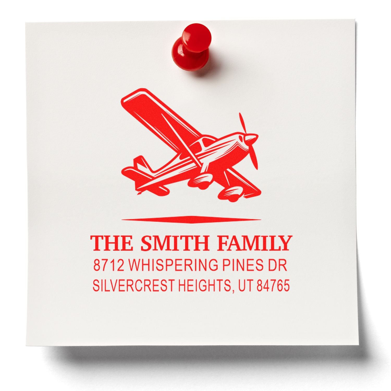 Custom red self-inking address stamp with airplane graphic for The Smith Family, showing Whispering Pines Dr, Silvercrest Heights, UT on white paper.