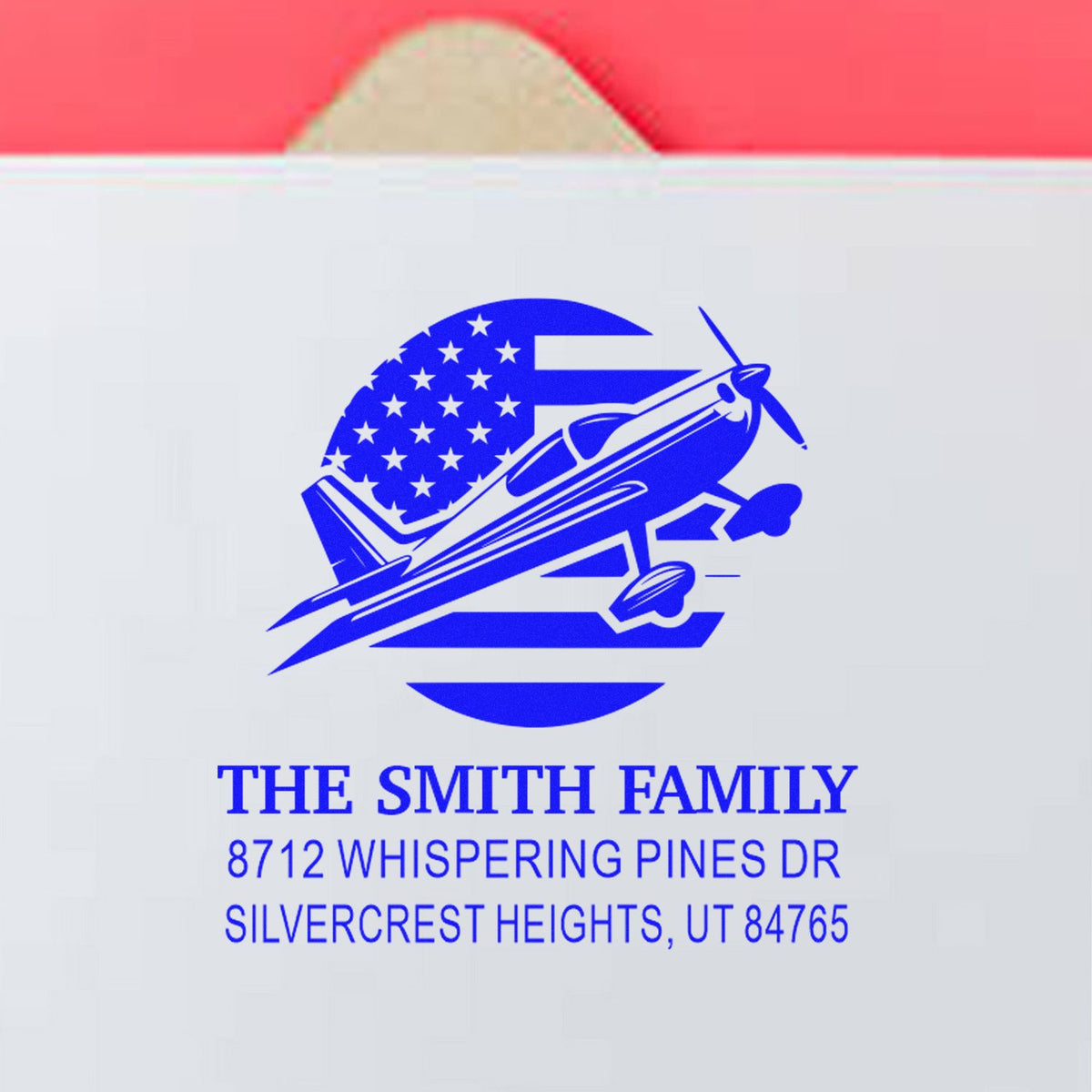 Custom blue return address stamp with airplane logo on white envelope for The Smith Family, 8712 Whispering Pines Dr, Silvercrest Heights, UT 84765.