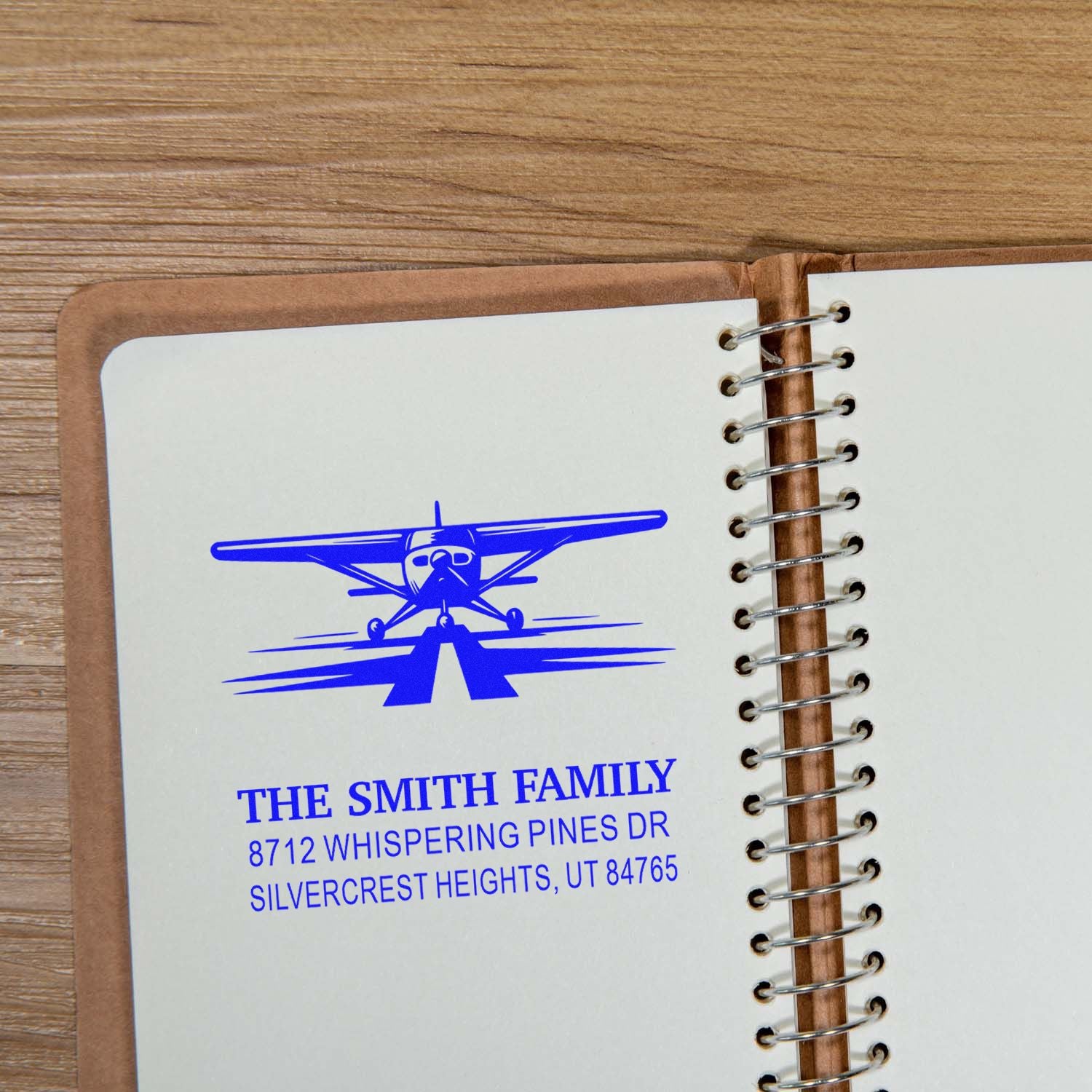 Custom rubber address stamp with blue airplane design and The Smith Family return address for notebooks, stationery, and mailing use