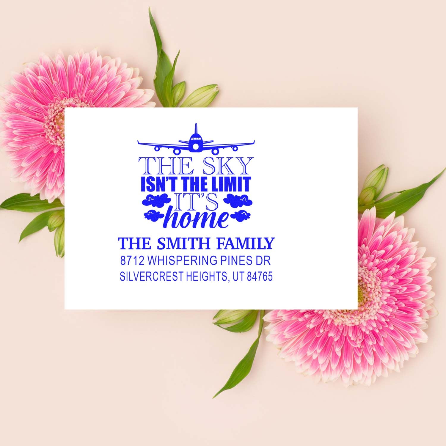Personalized return address stamp with airplane and The sky isnt the limit, its home quote on a pink gerbera floral background.