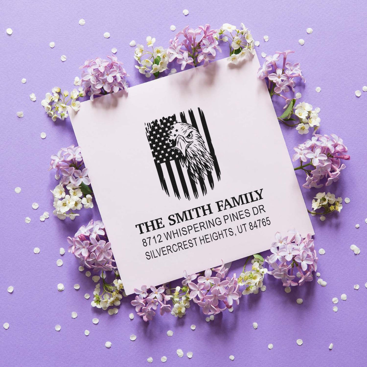 Custom family address stamp with eagle and American flag design on lilac background, surrounded by flowers and confetti