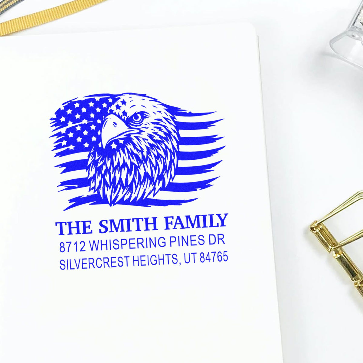 Blue custom family address stamp on white paper, featuring an eagle over an American flag and The Smith Family Silvercrest Heights address.
