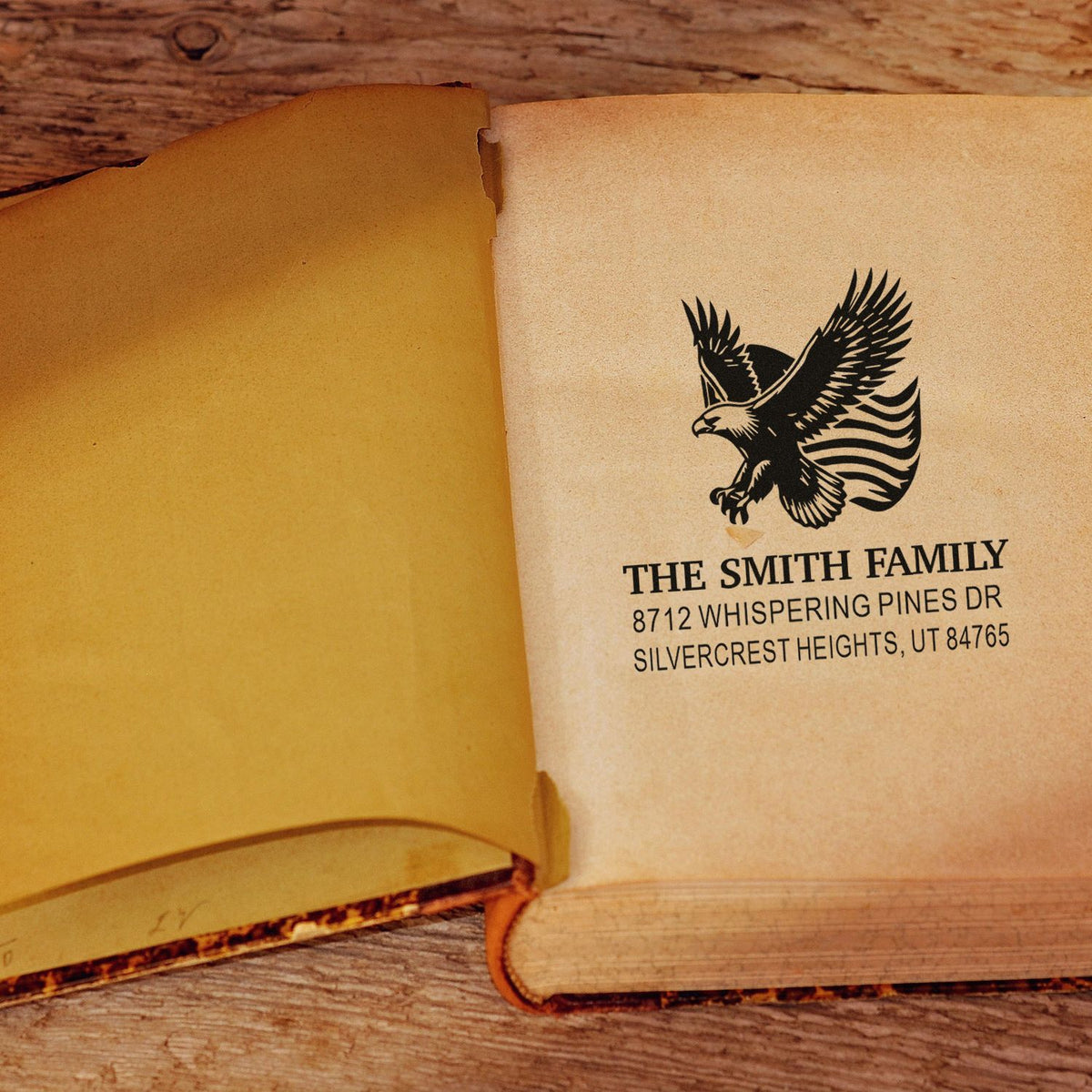 Custom rubber address stamp with eagle design, The Smith Family name and Utah address printed on a book page for personalized mailing and stationery