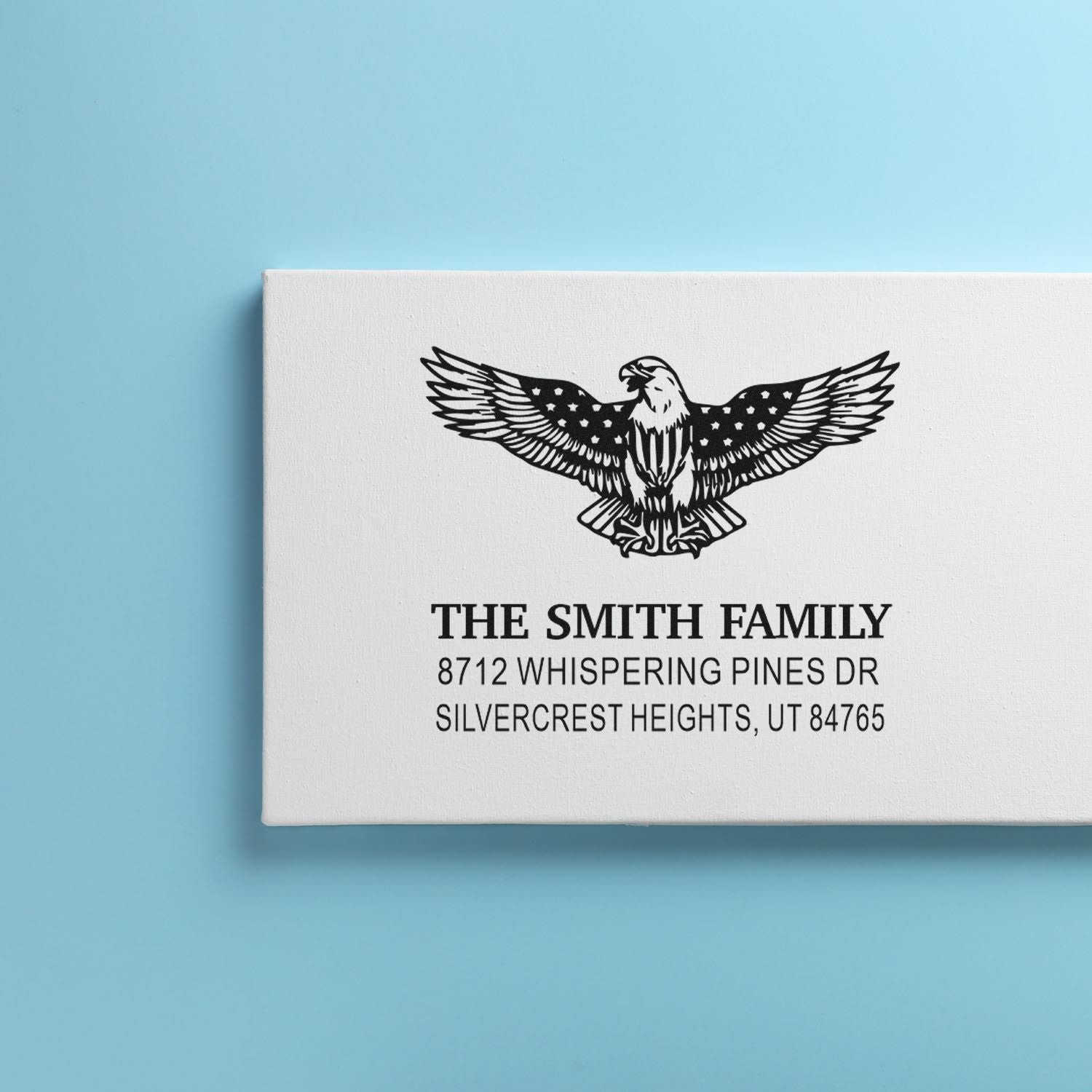 Custom rubber return address stamp with eagle design for The Smith Family, featuring personalized name and home address in bold black print.