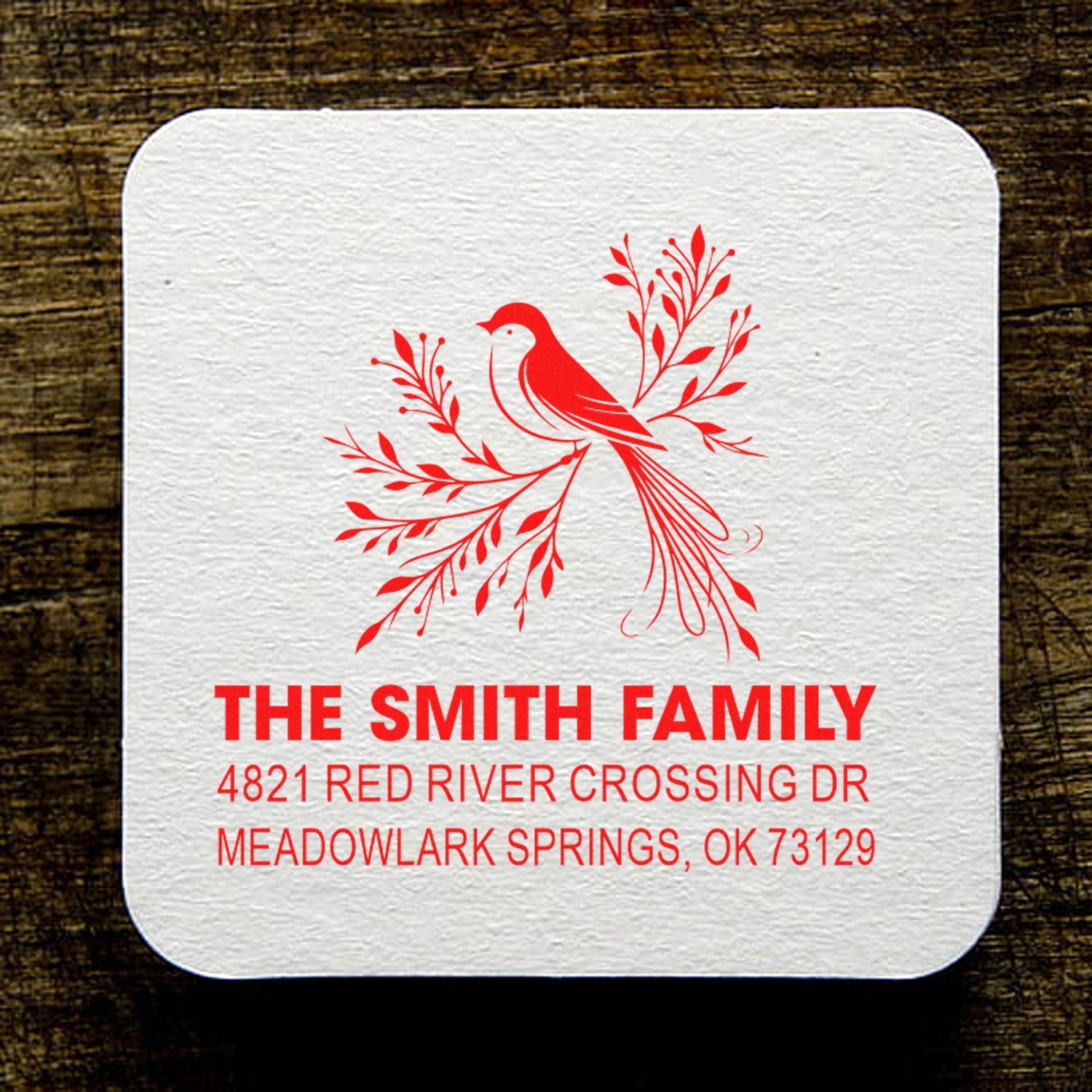 Personalized rubber address stamp with red bird and floral branch design, The Smith Family name, and custom return address for mail, envelopes, and stationery.
