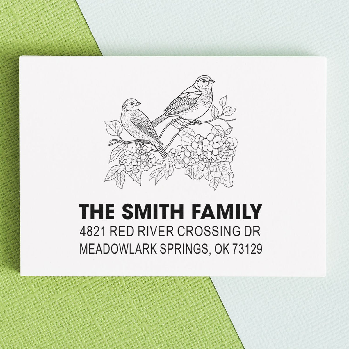 Custom return address rubber stamp with two birds and floral branch design, personalized family name, street address and city for mailing envelopes.