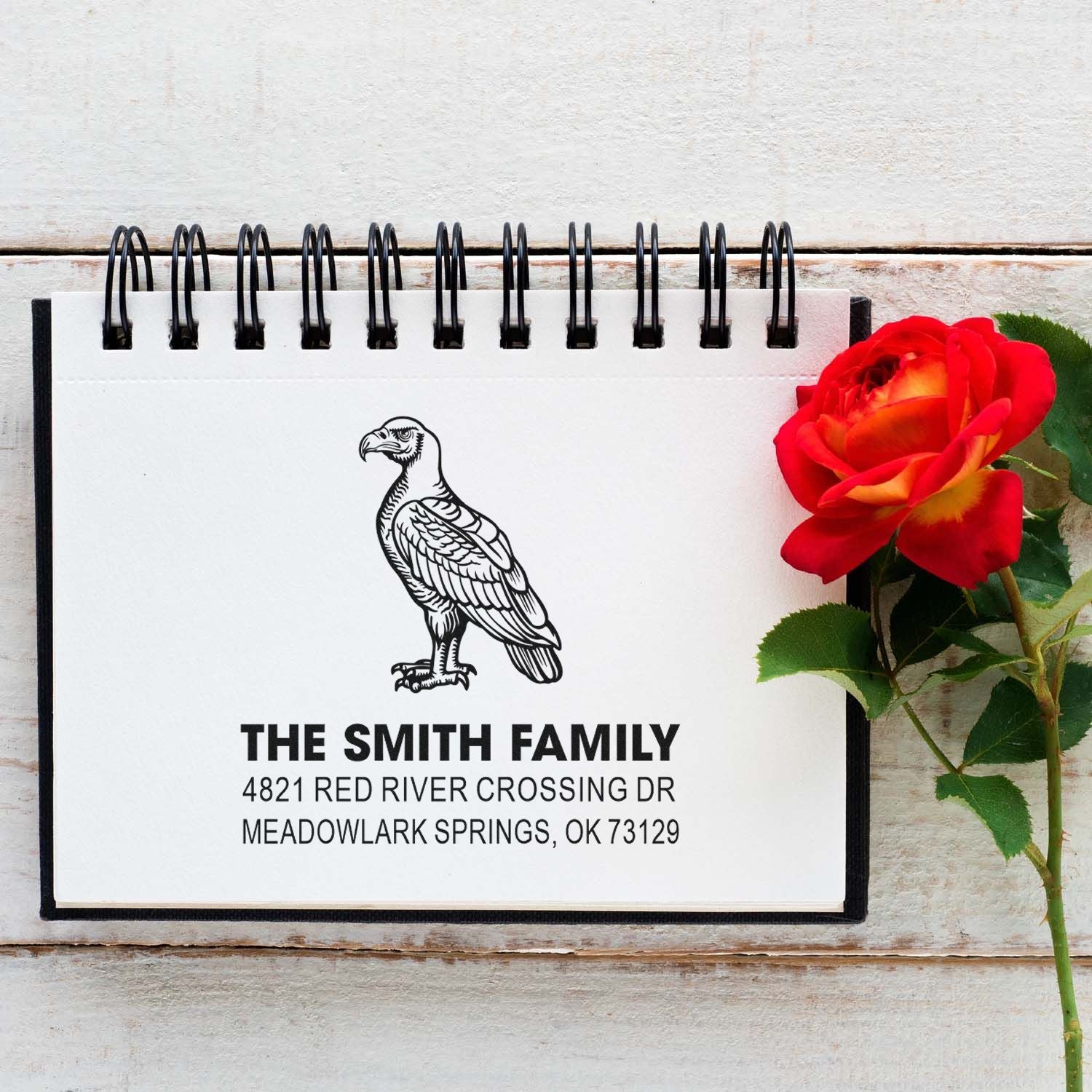 Custom eagle family address rubber stamp with The Smith Family name and Meadowlark Springs, OK return address on a spiral notebook for stationery.