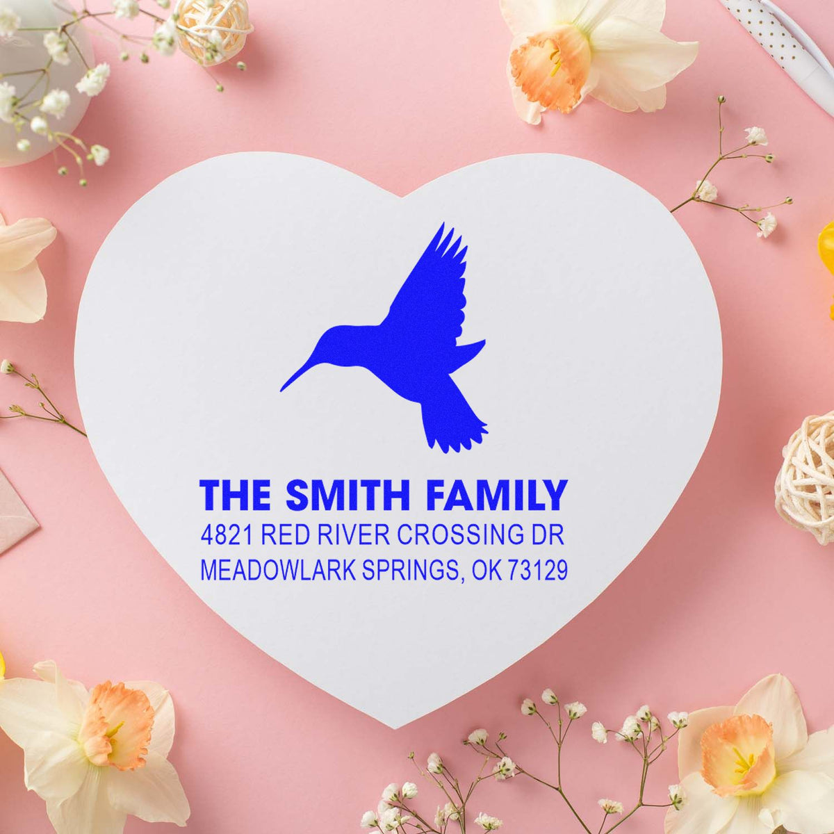 Heart-shaped custom return address rubber stamp with hummingbird design for The Smith Family, featuring blue ink-style name and address printing.