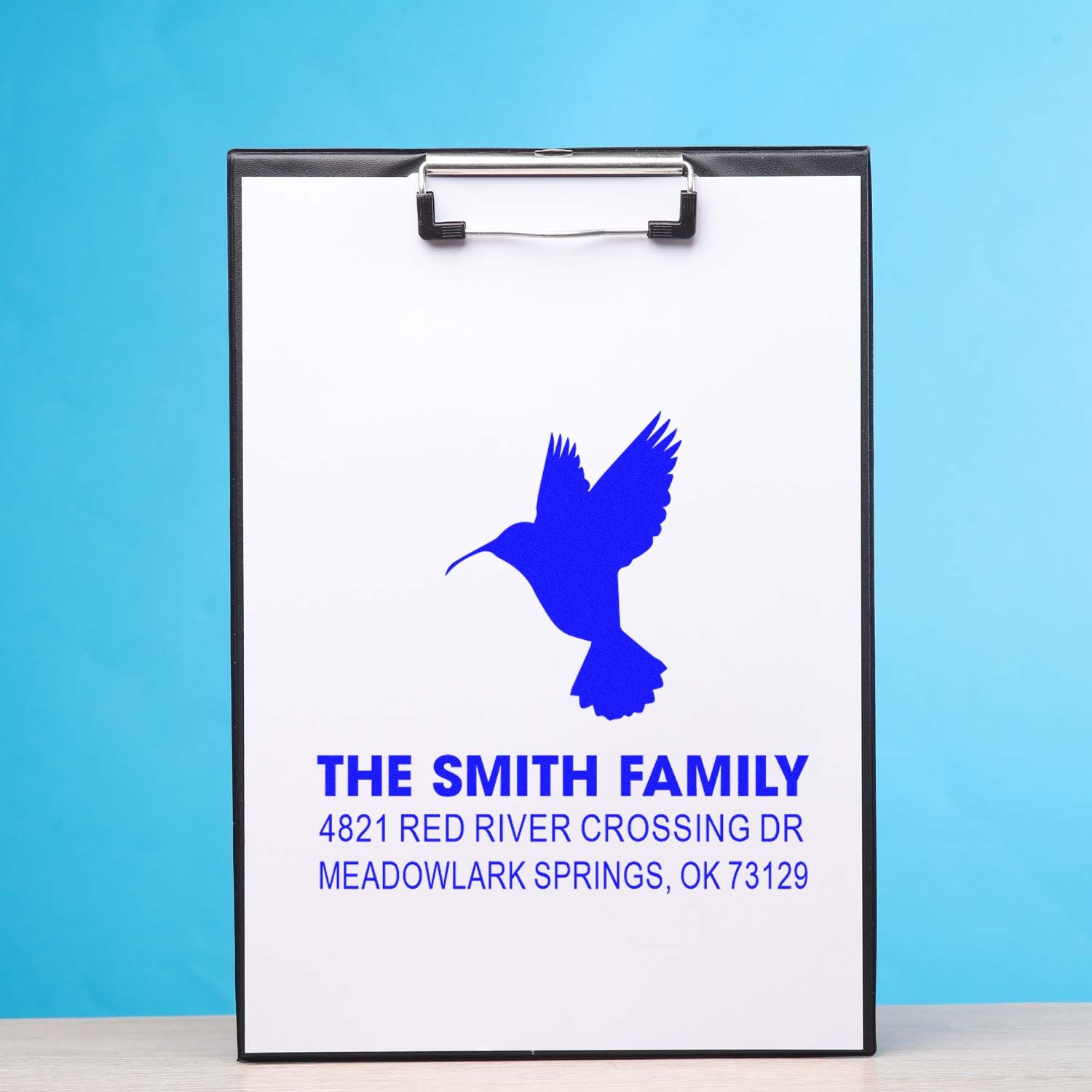 Custom family address rubber stamp design with hummingbird logo on clipboard, personalized return address stamp for home, mail, and business use