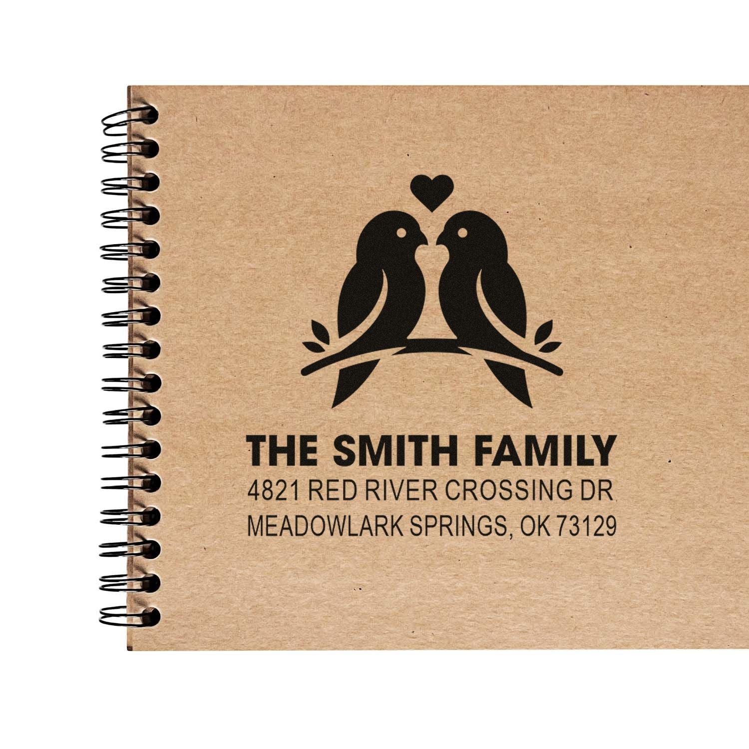 Custom return address rubber stamp with birds and heart design, featuring The Smith Family name and Meadowlark Springs, OK on kraft paper notebook