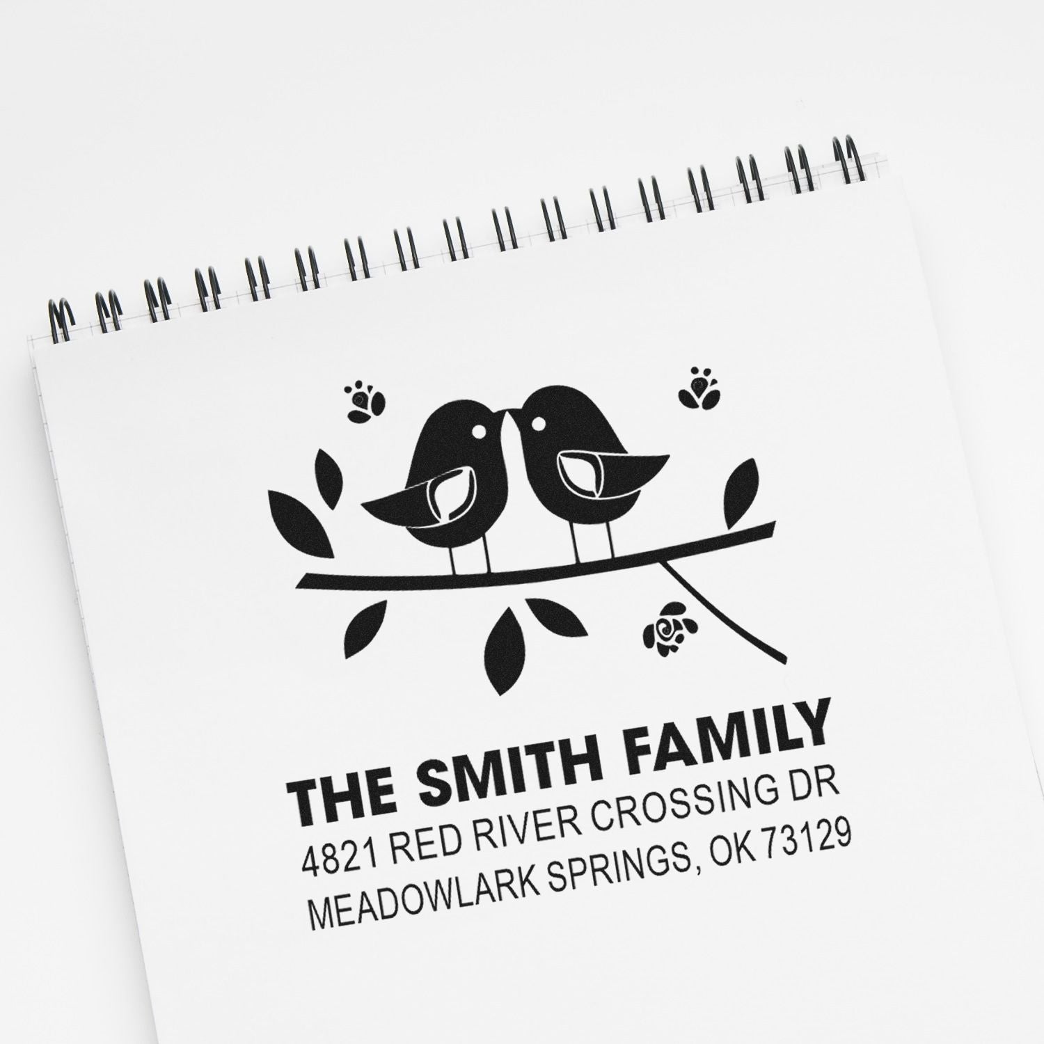 Personalized rubber return address stamp featuring two birds on a branch, family name, street address, and city for custom envelopes.